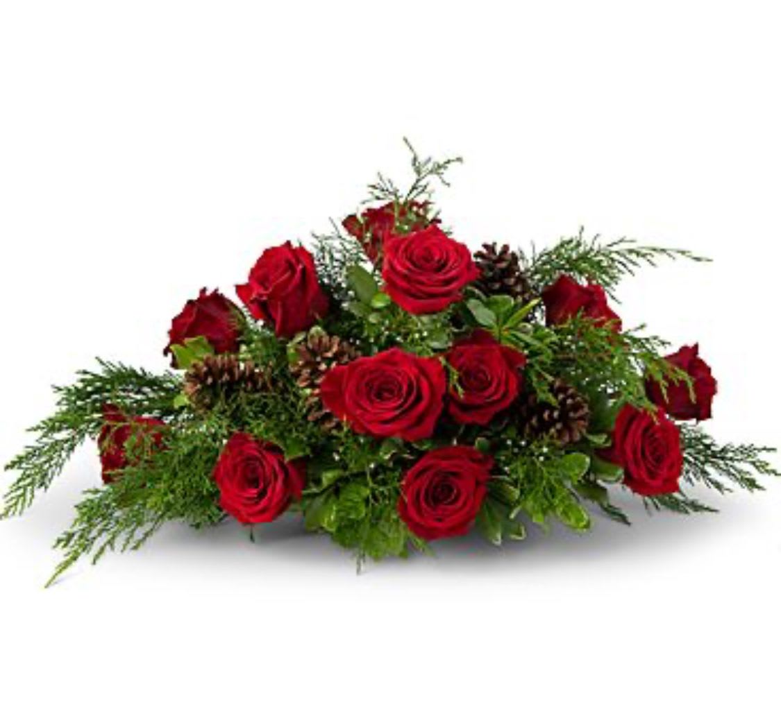 Low arrangement of red roses with pinecones and evergreen accents