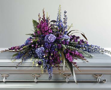 Purple floral spray on a silver casket