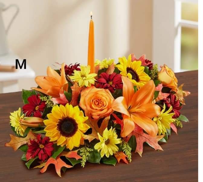 Autumn floral centerpiece with a tall orange candle