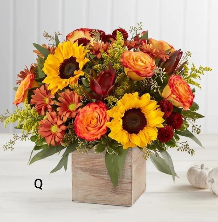 Mixed bouquet of sunflowers, roses, and mums in a wooden box