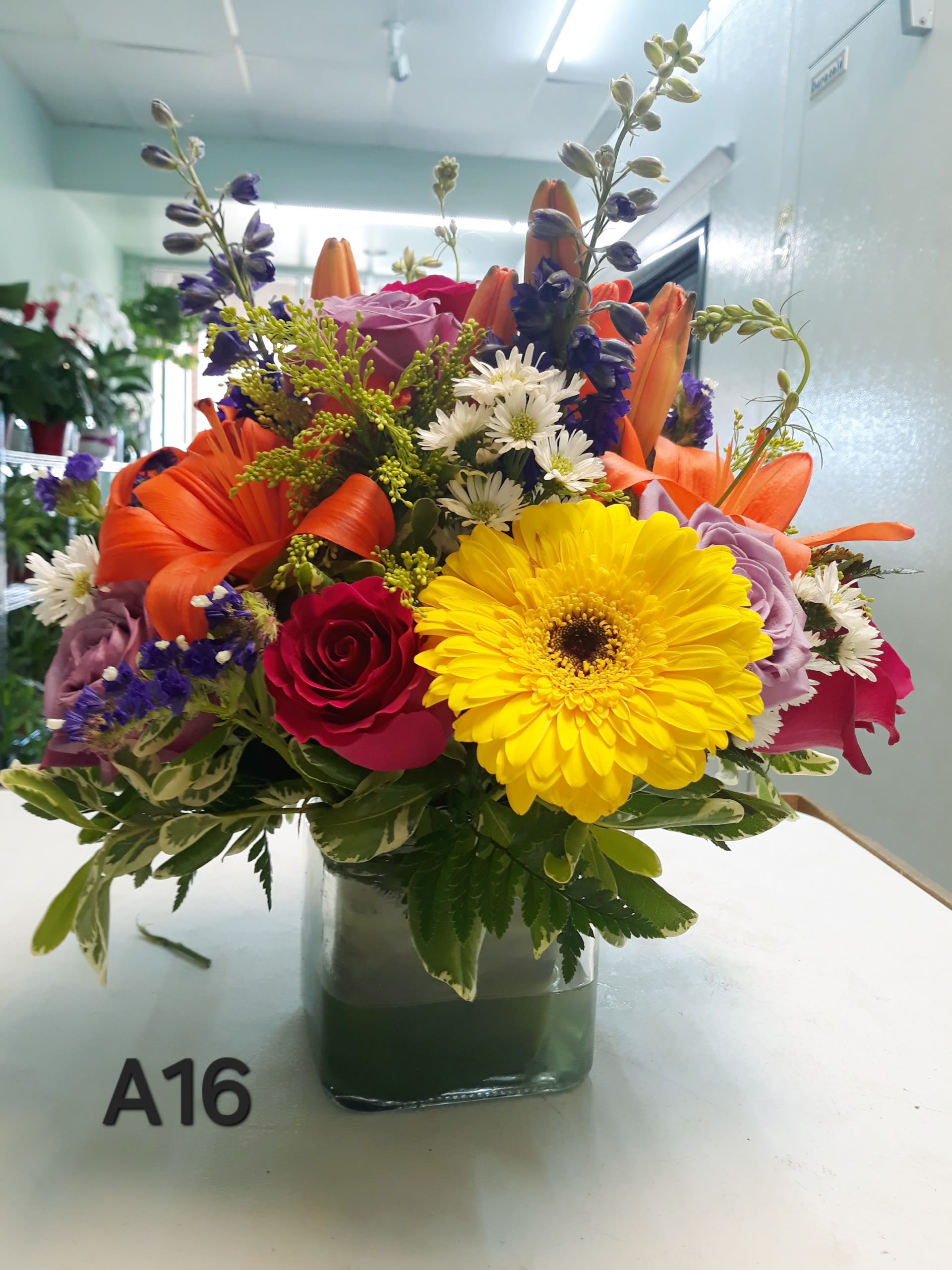Colorful mixed bouquet in a square glass vase