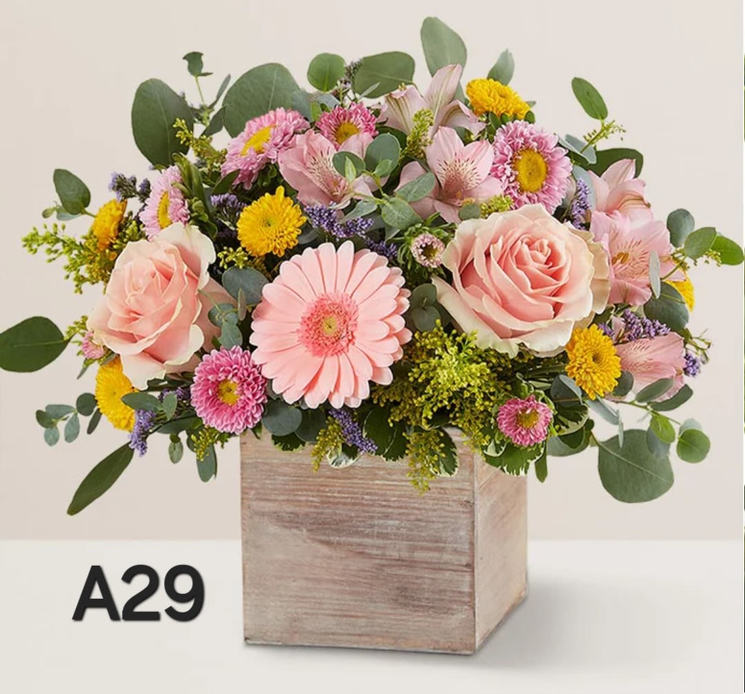 Pink and yellow mixed flower arrangement in a wooden box