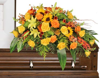 Yellow and orange floral spray on a wooden casket