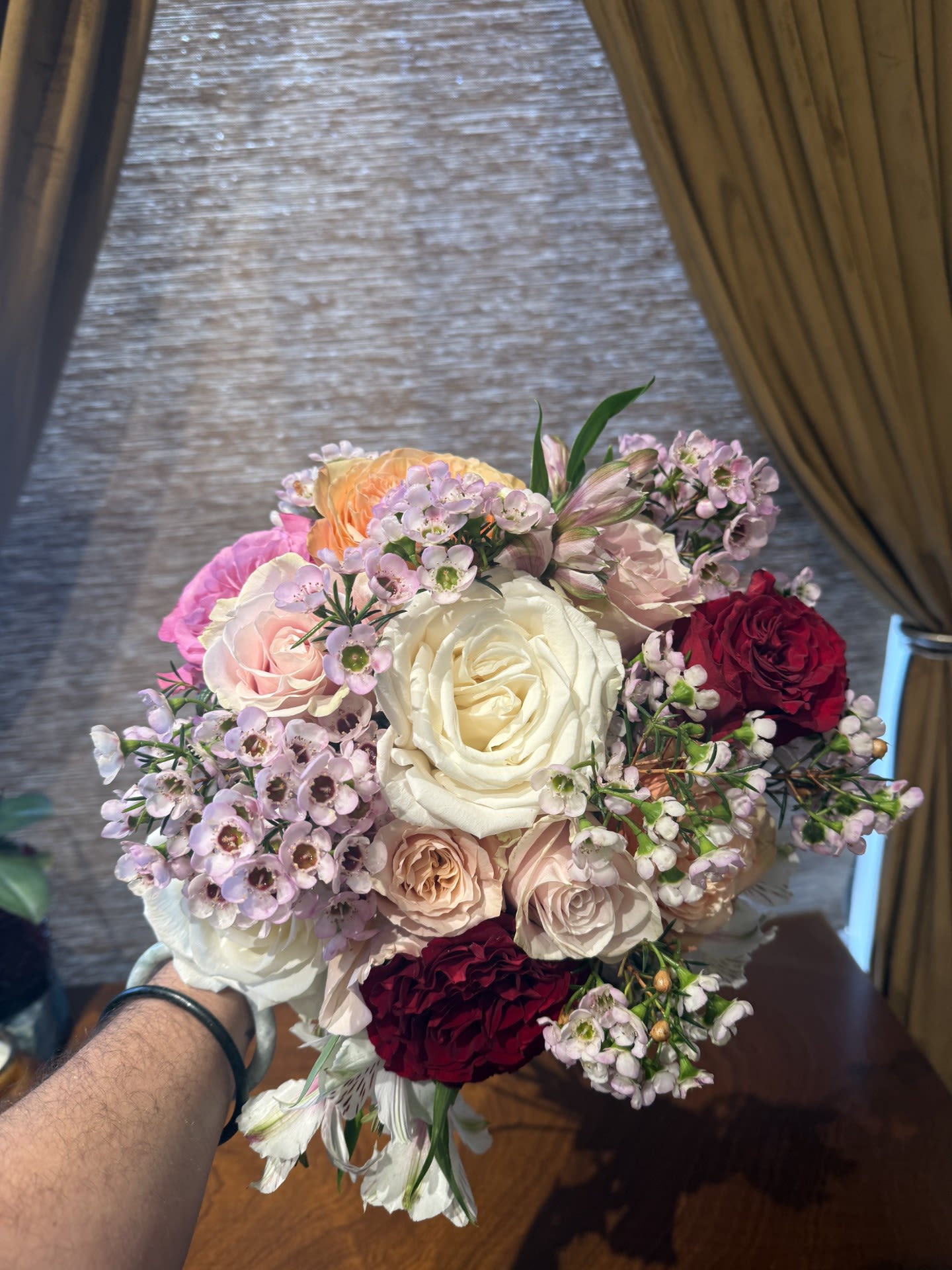 First Kiss: Hand-tied Bouquet - FIRST KISS  Soft, airy, and romantic. A bloom-forward hand-tied bouquet featuring Pink Expression and Queen’s Crown roses, lightly accented with delicate waxflower for movement and texture.  PART OF OUR LOVE IN EVERY ERA — HAND-TIED BOUQUET COLLECTION Featuring First Kiss, All In, and After Dark  This Valentine’s collection is intentionally bloom-forward, designed around a tightly curated selection of premium rose varieties. To honor the integrity of each design, we are limiting our Valentine’s stock to these featured blooms, allowing the flowers themselves to take center stage. Our hand-tied bouquets are lush, expressive, and light on traditional fillers; instead, we use delicate waxflower as our primary accent to maintain a refined, floral-forward composition.  Images shown are renderings and are representative of overall size, style, and color palette.