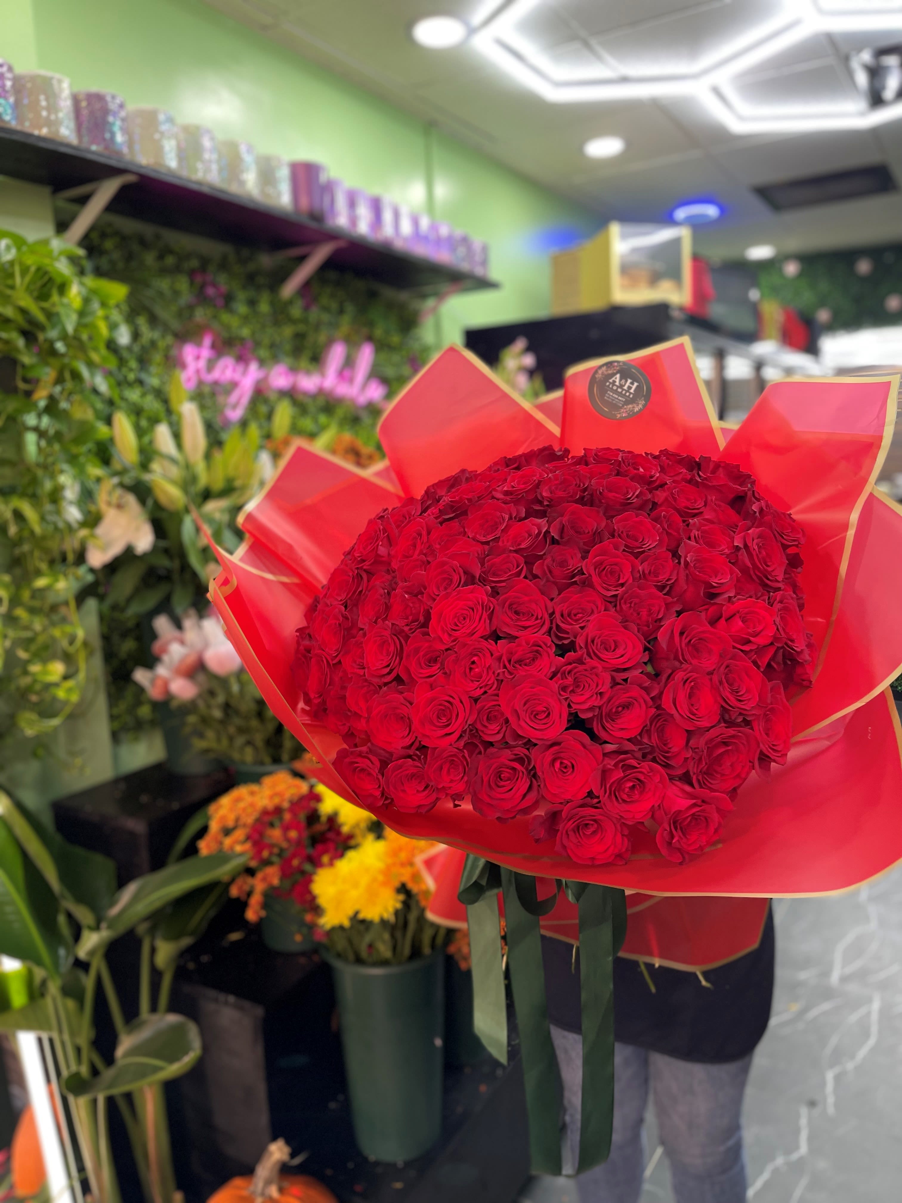 Large bouquet of red roses wrapped in red paper