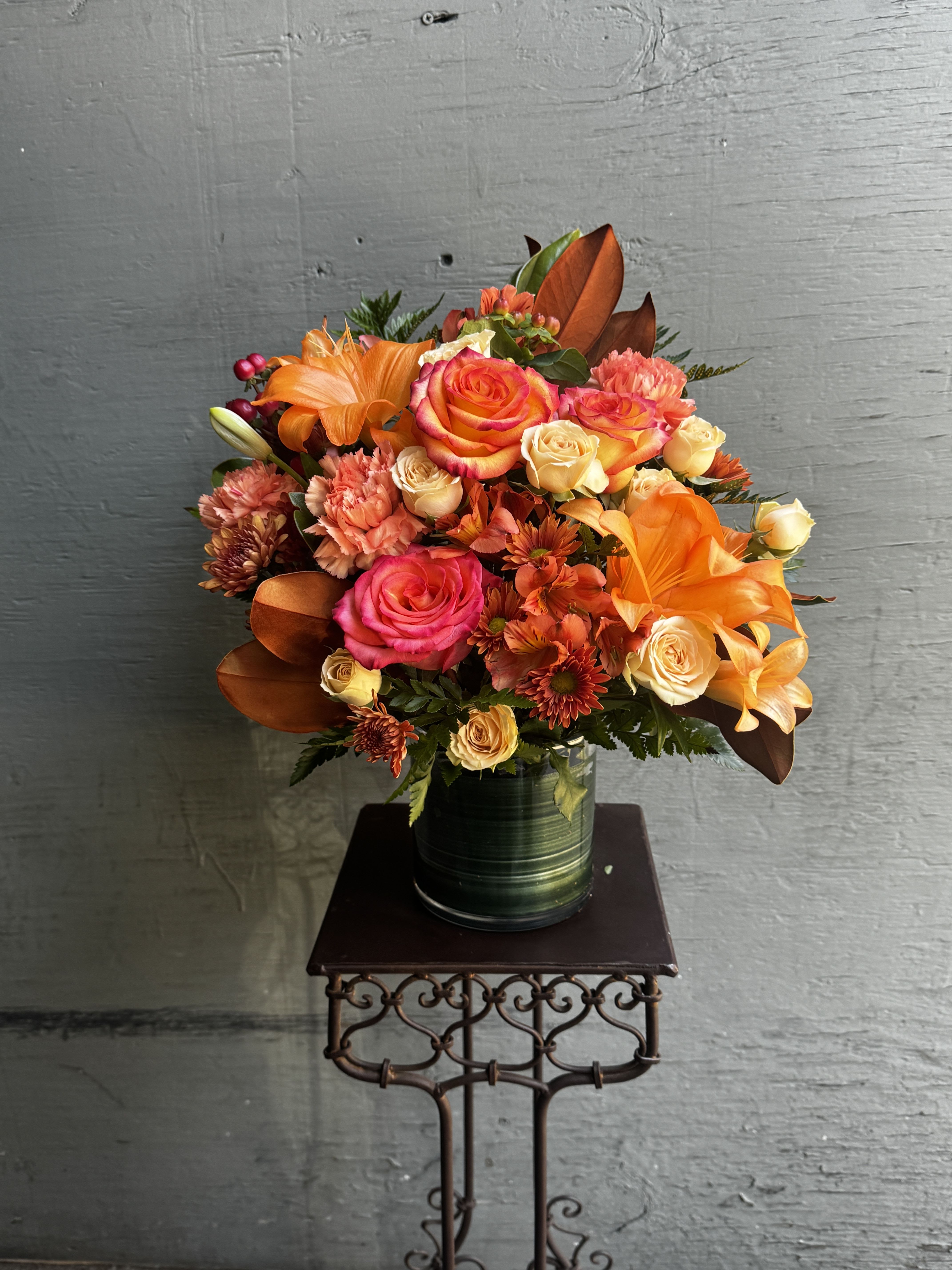 Bouquet of orange and pink roses in a green vase