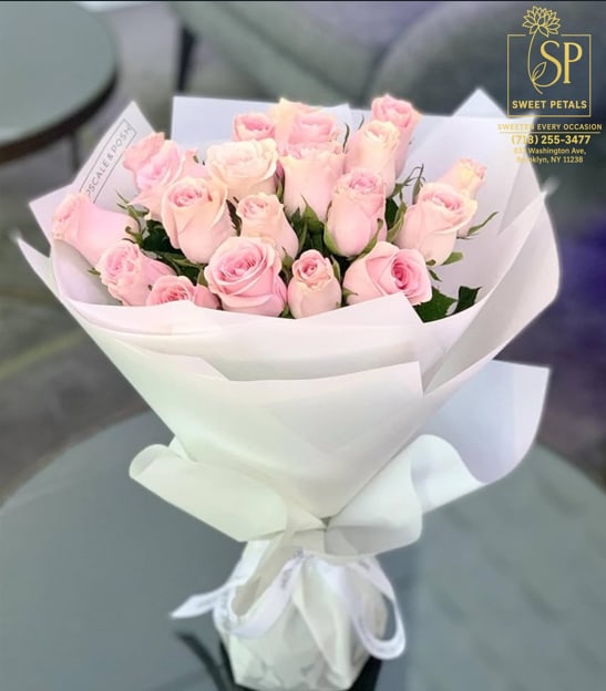 Bouquet of pale pink roses wrapped in white paper