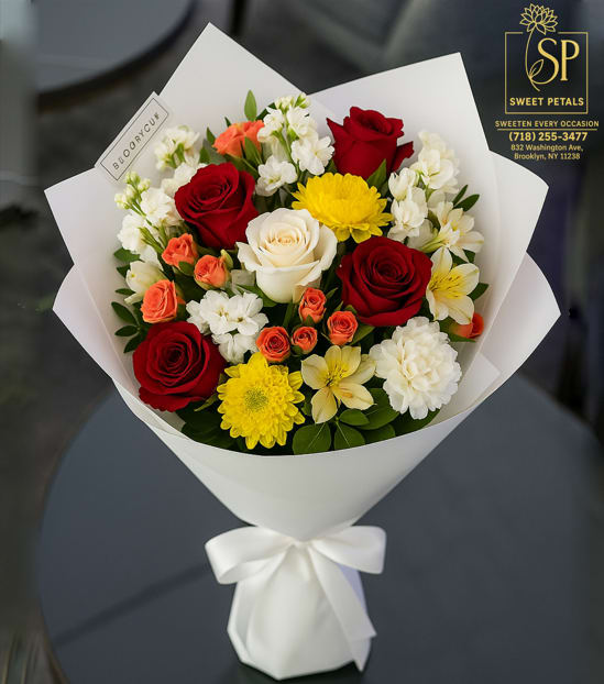 Bouquet of red, white, and yellow flowers wrapped in white paper