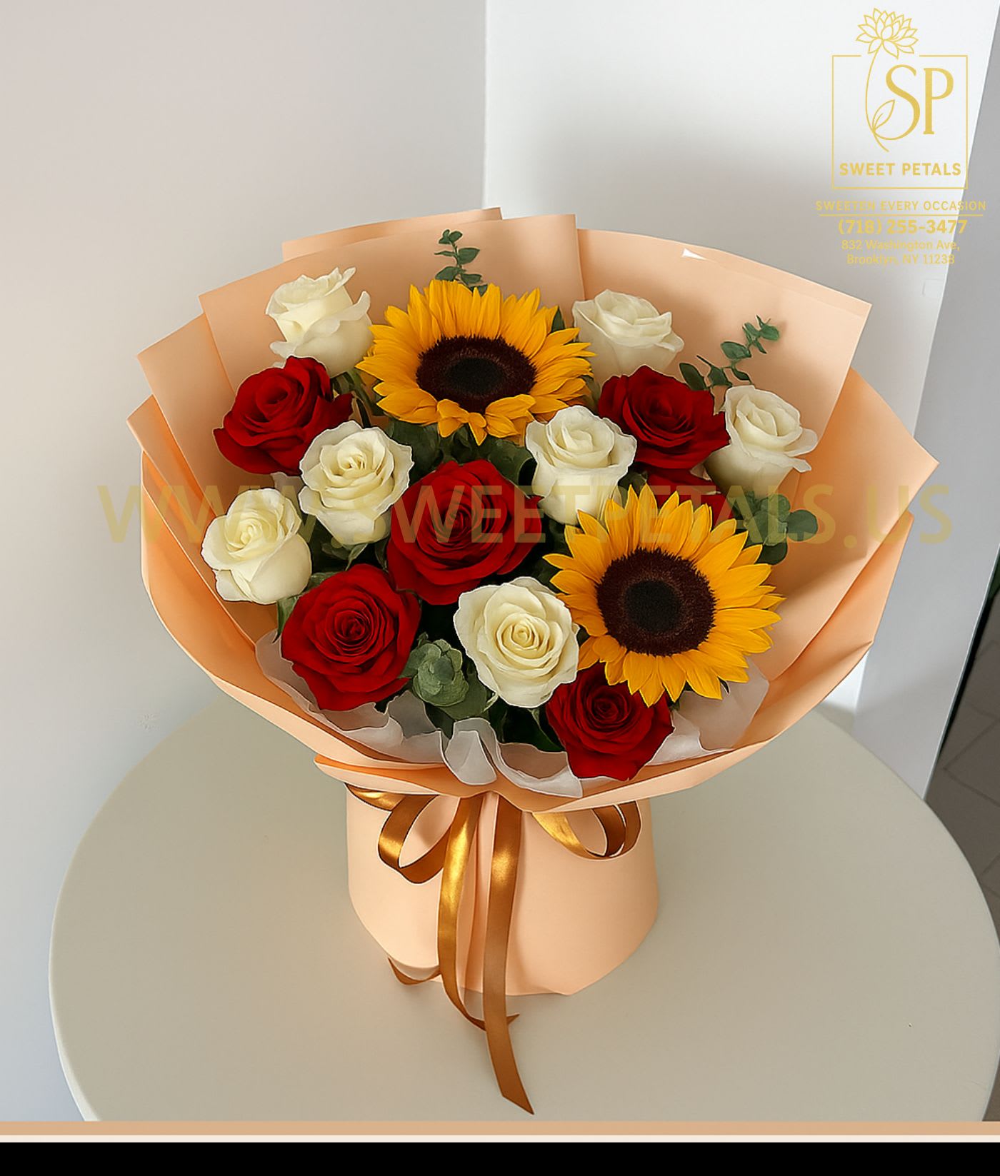 Bouquet of red and white roses with two sunflowers in peach wrapping