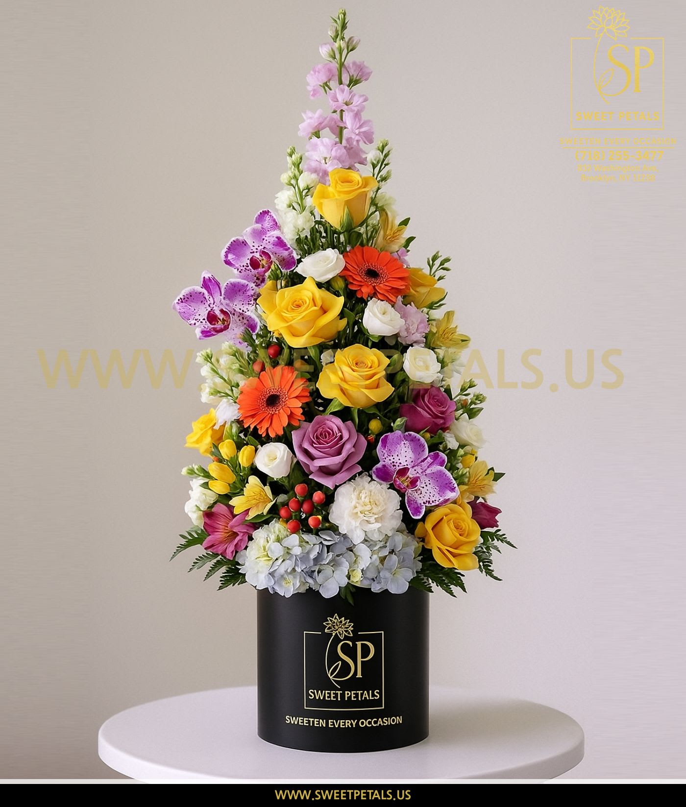 Tall mixed flower arrangement in a black cylindrical box