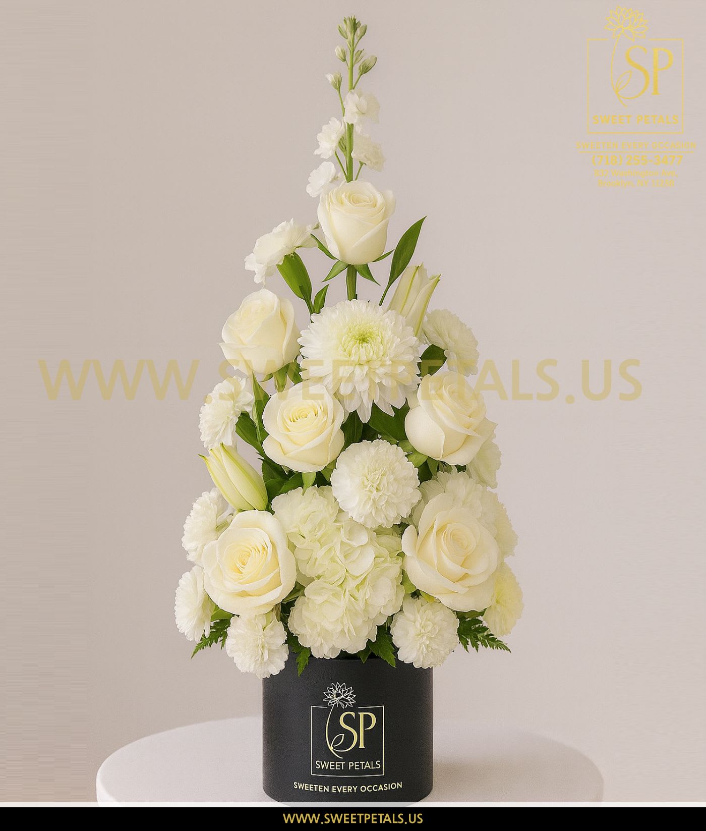 White roses and mums arranged in a black box vase