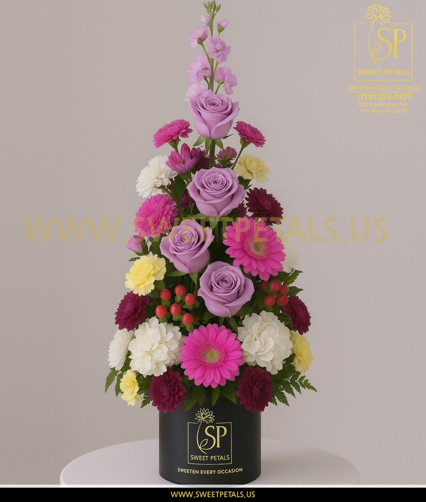 Tiered bouquet of lavender roses, pink gerberas, and mixed daisies in a black box