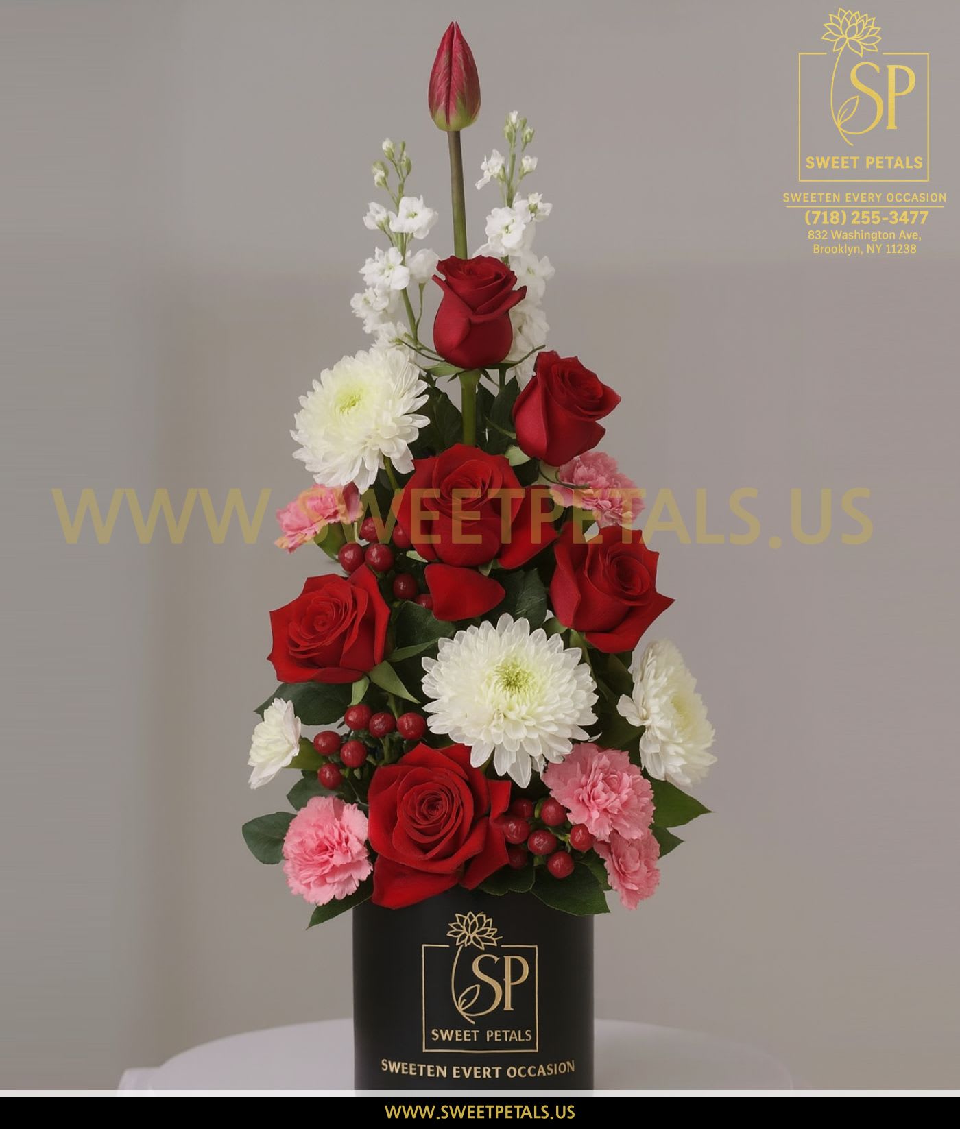 Tall red rose arrangement with white and pink flowers in a black box