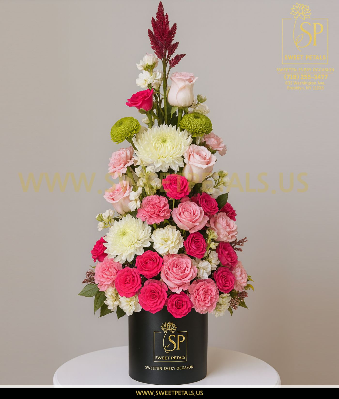 Tall pink and white floral arrangement in a black cylinder box