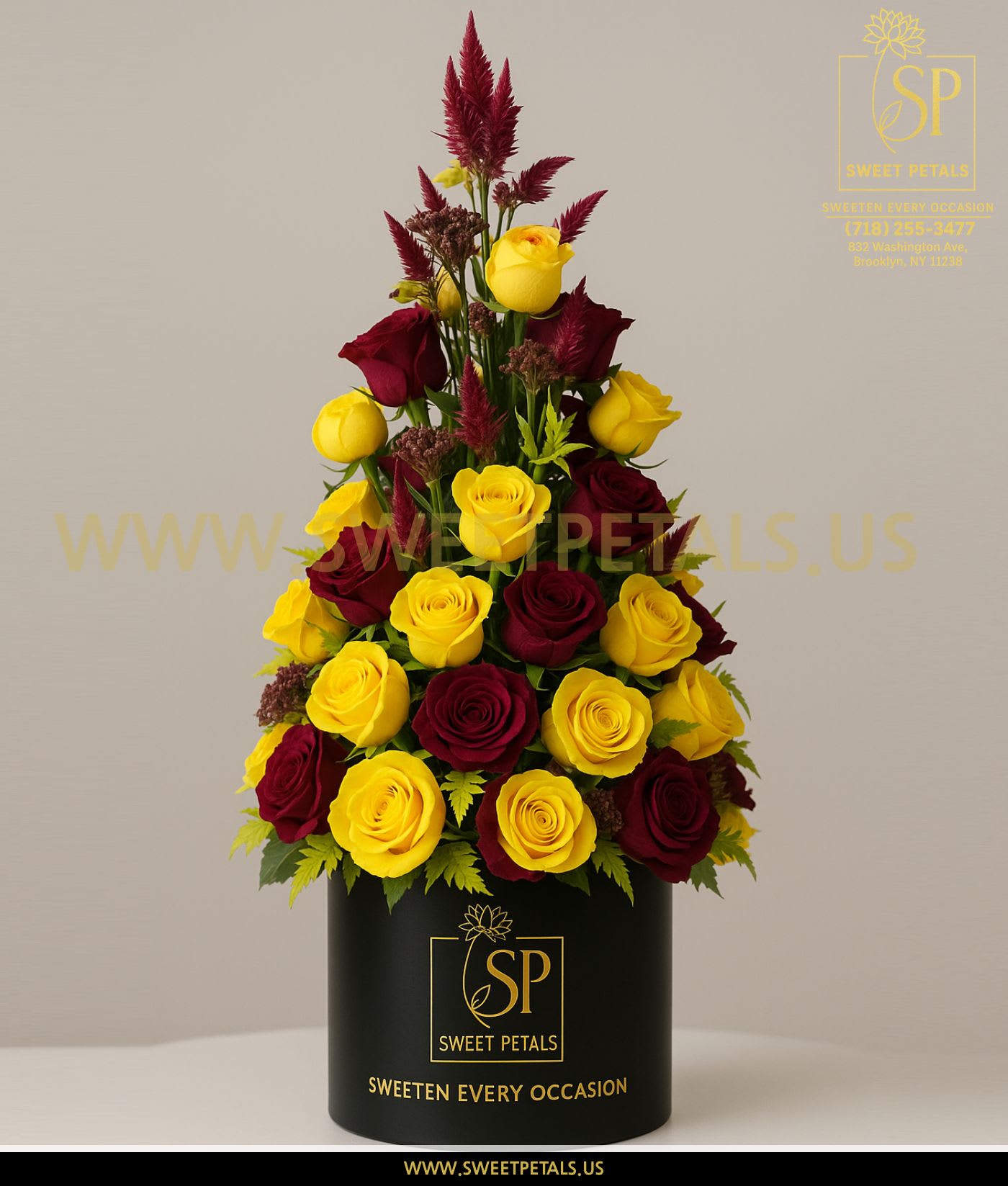 Tall arrangement of yellow and burgundy roses in a black box