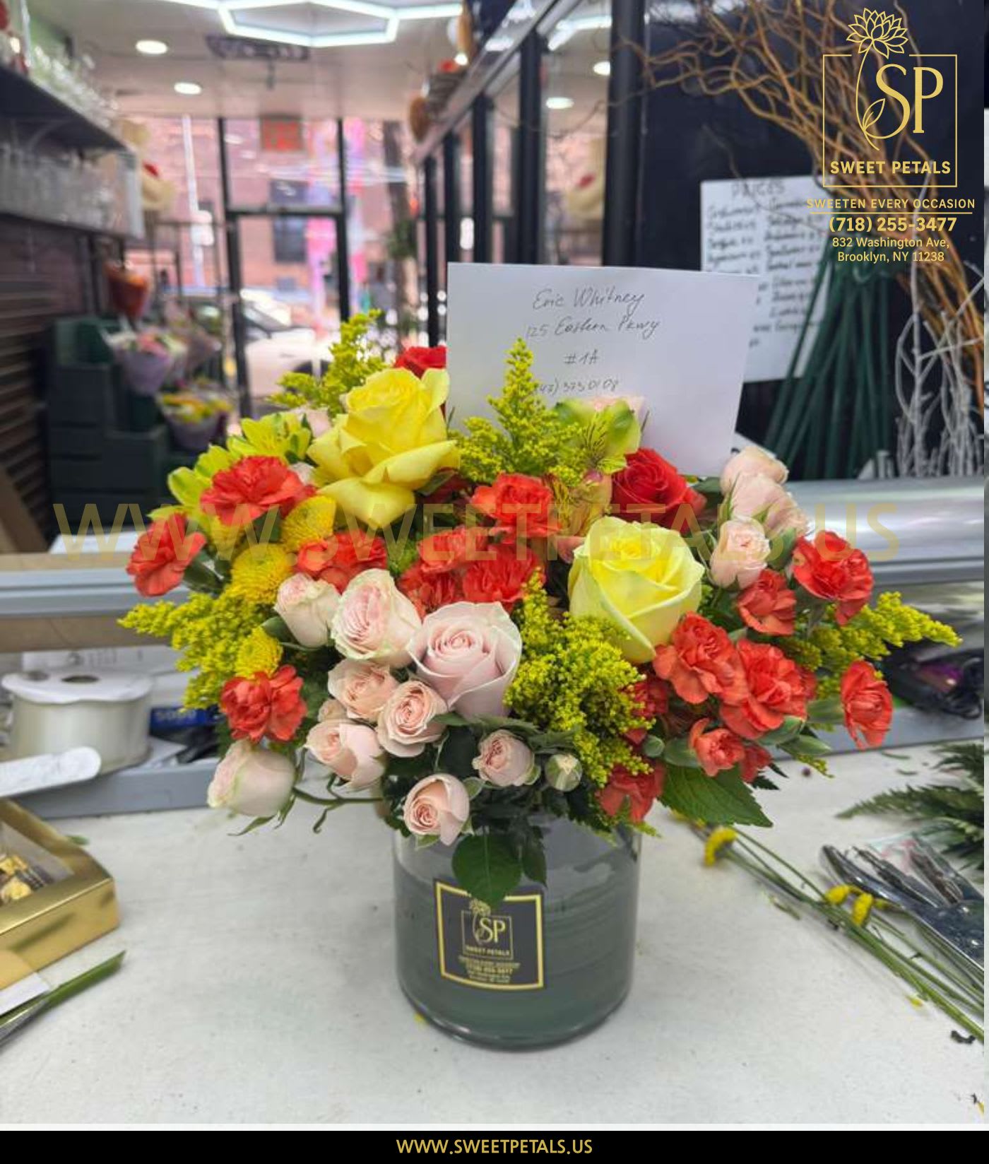 Mixed bouquet of yellow, pink, and red roses in a glass vase