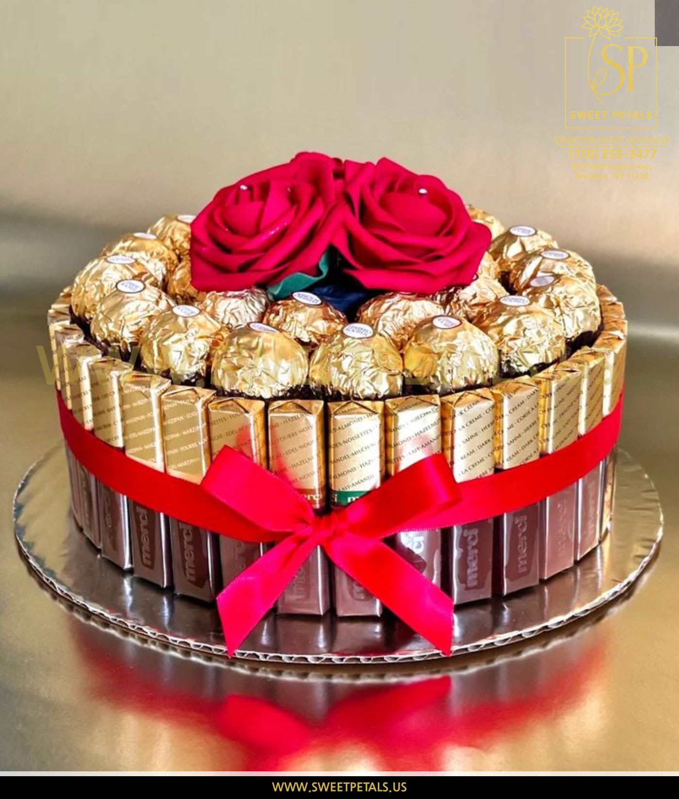 Chocolate gift box topped with two red roses and a ribbon