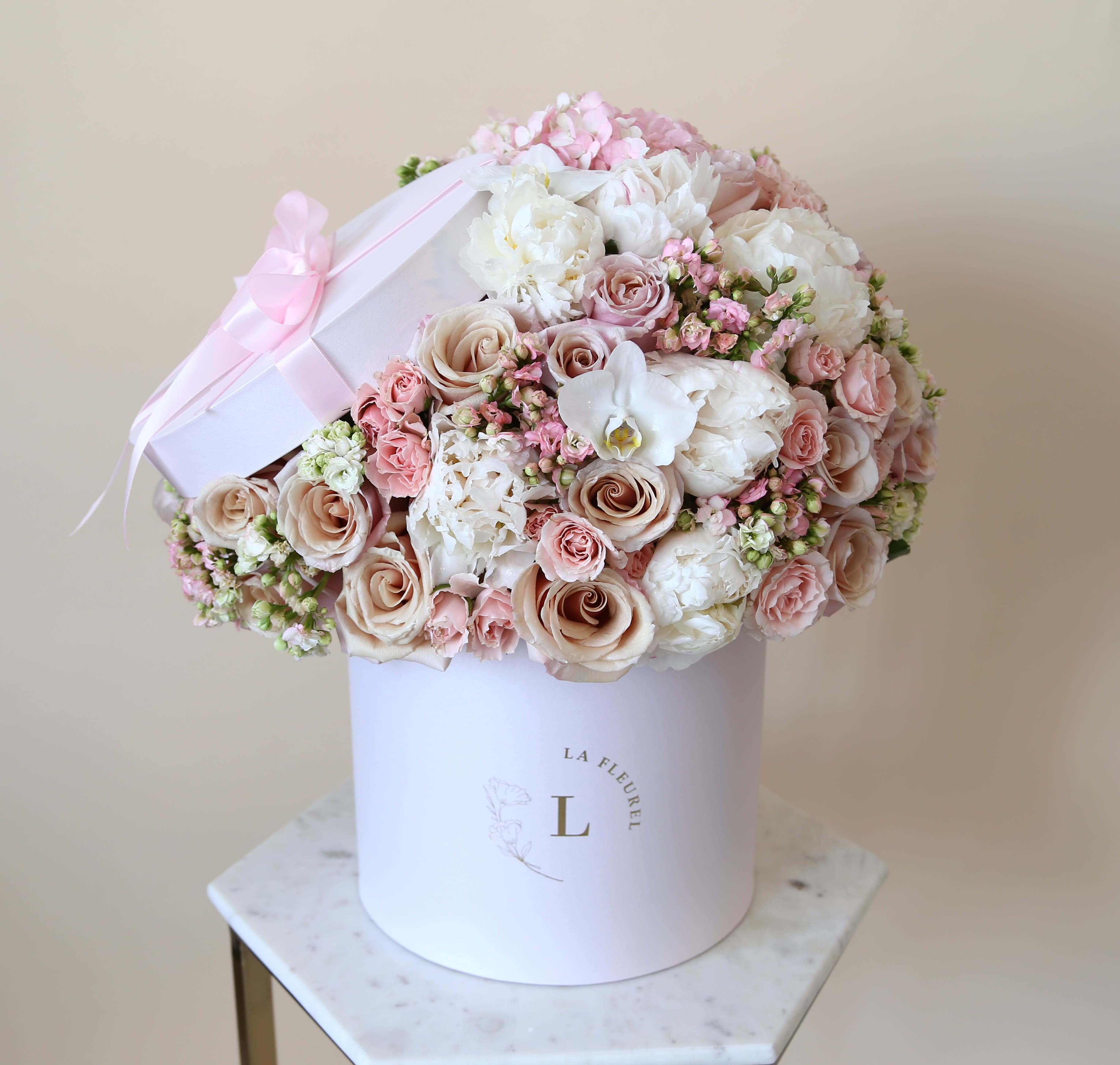 Pink Beauty - This delicate arrangement filled with the light pink and beige roses,hydrangeas, greens, orchids and peonies to deliver your special message to your special someone. Perfect for any occasion.   Arrangement includes: Fresh pink, beige roses, orhcids, peonies, greens and hydrangeas Medium box measured at 9.75" Dia. x 9.25" H Custom greeting card