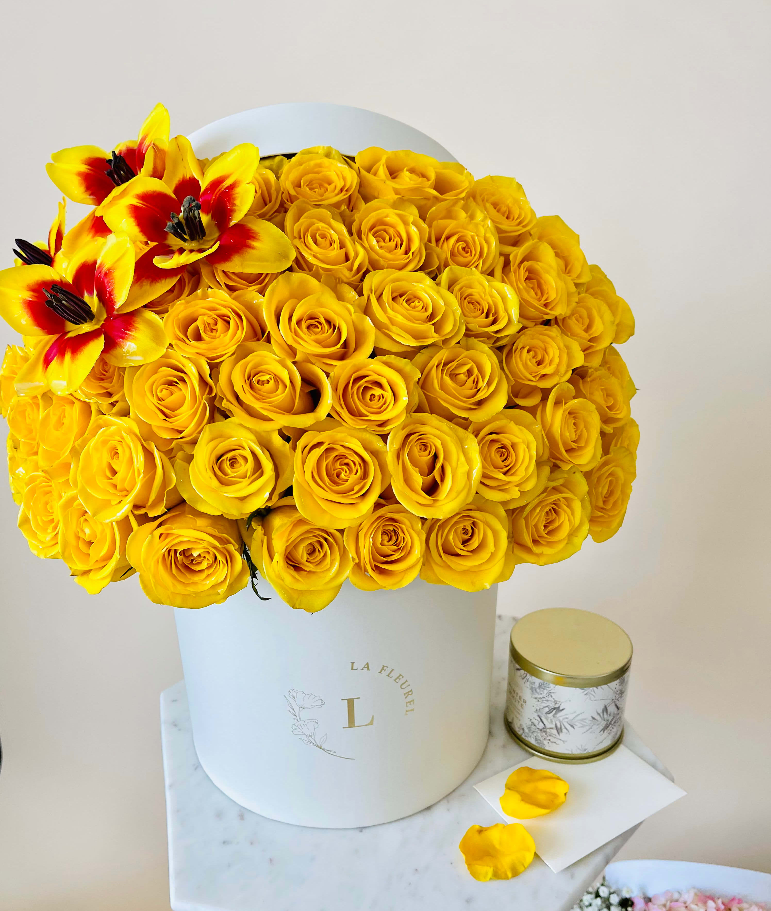 Yellow Roses Arrangement - Yellow and glory in this composition are presented with roses and tulips. With this romantic floral arrangement you can open your heart and your feelings to your beloved.  Arrangement includes: Medium box measured at 9.75" Dia. x 9.25" H Custom greeting card