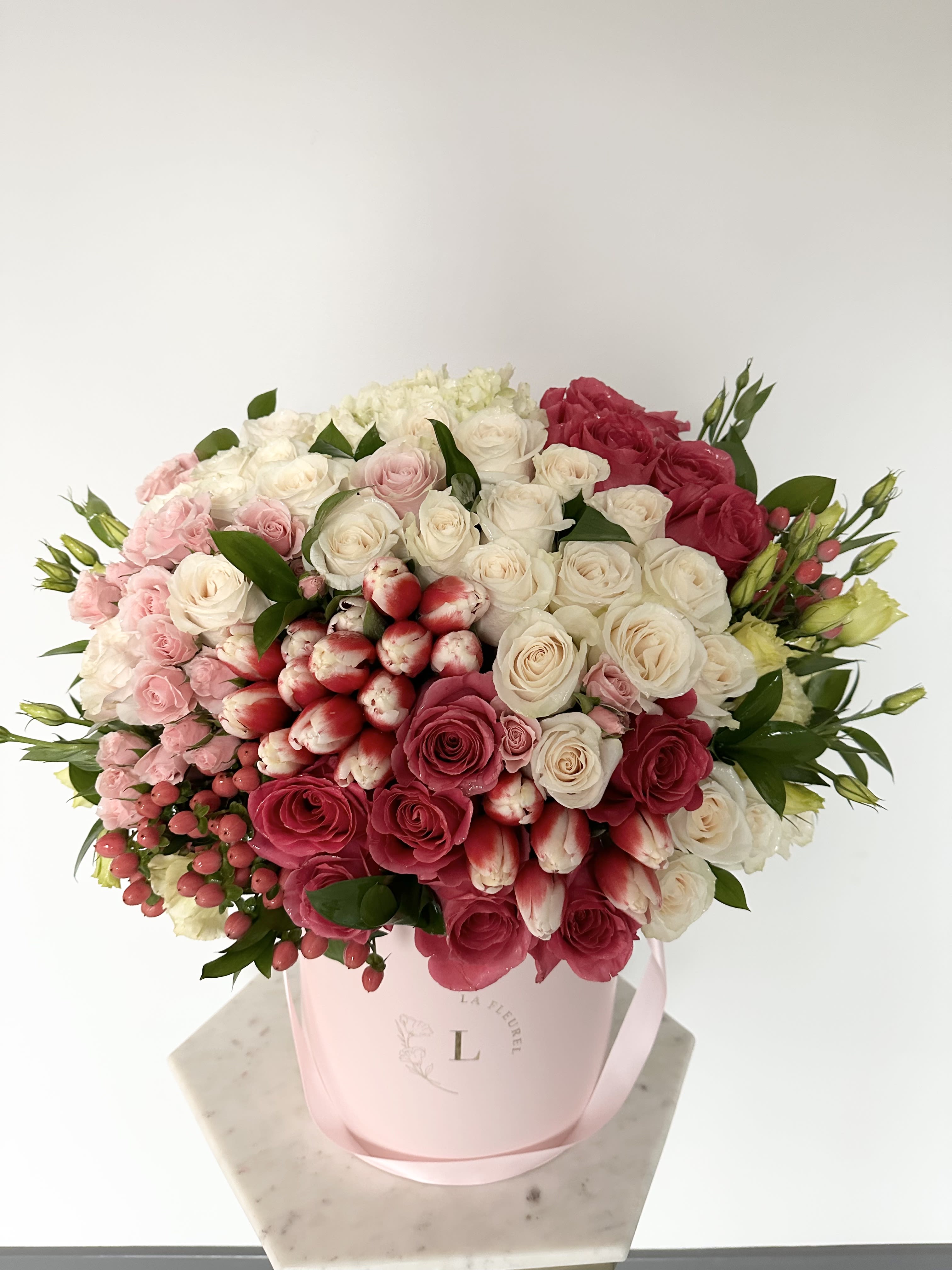 Evelina Arrangement - This beautiful arrangement filled with the roses, tulips, hydrangeas and greens to deliver your special message to your special someone.  Perfect for any occasion. You can choose any color of the box.  Arrangement includes: Medium box measured at 9.75" Dia. x 9.25" H Custom greeting card