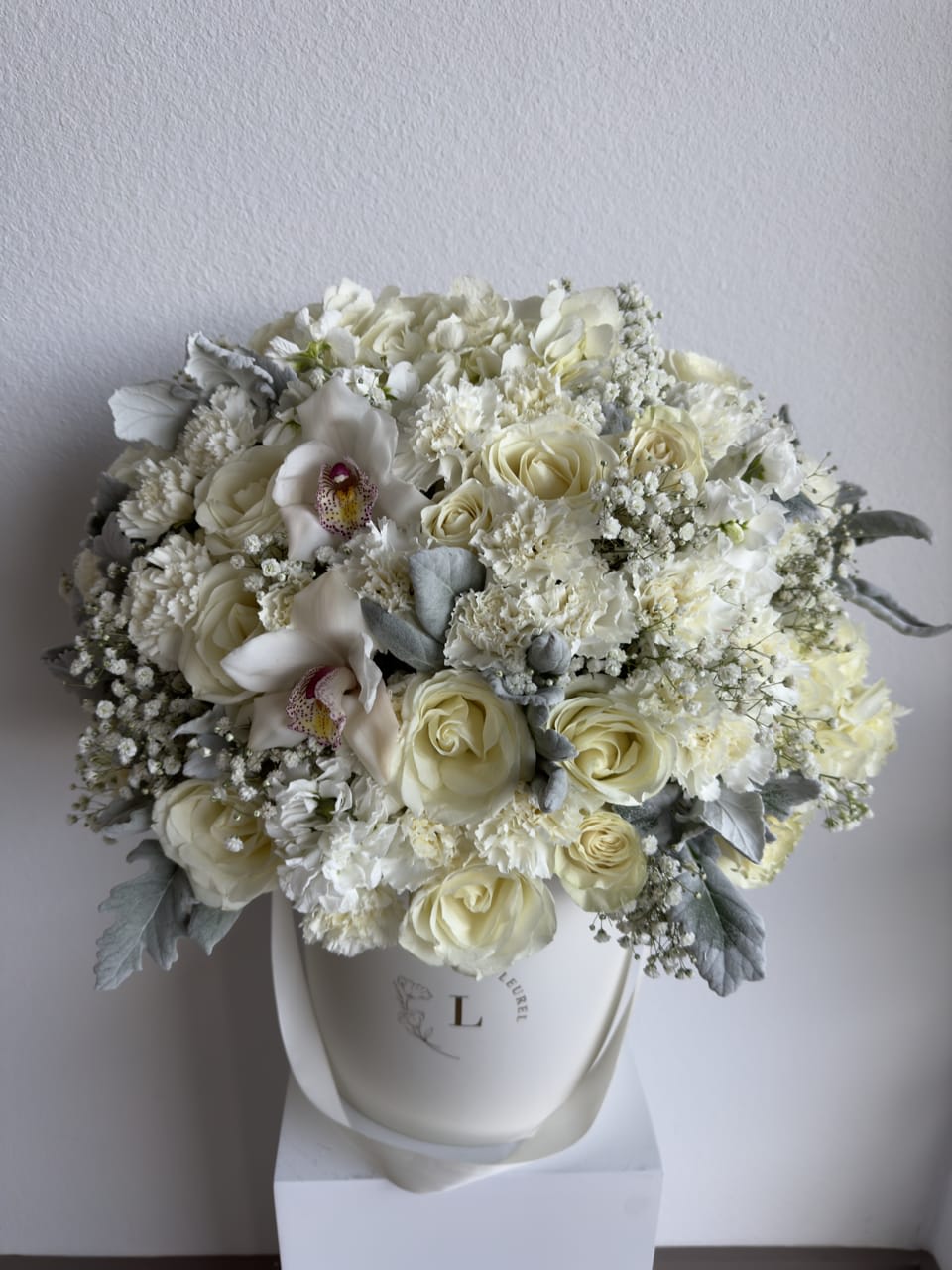 Winter Morning - This beautiful arrangement is filled with white roses to deliver your special message to your special someone.  Perfect for any occasion. You can choose any color of the box.  Arrangement includes: white roses, hydrangea, carnations and dusty miller Medium box measured at 9.75" Dia. x 9.25" H Custom greeting card 
