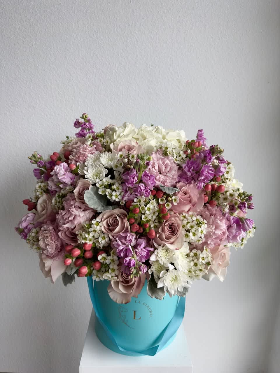 Colorful Spring - This beautiful arrangement is filled with pink roses, hydrangeas, stock, coffee beans and greens to deliver your special message to your special someone.  Perfect for any occasion. You can choose any color of the box.  Arrangement includes: white roses, hydrangea, carnations and dusty miller Medium box measured at 9.75" Dia. x 9.25" H Custom greeting card