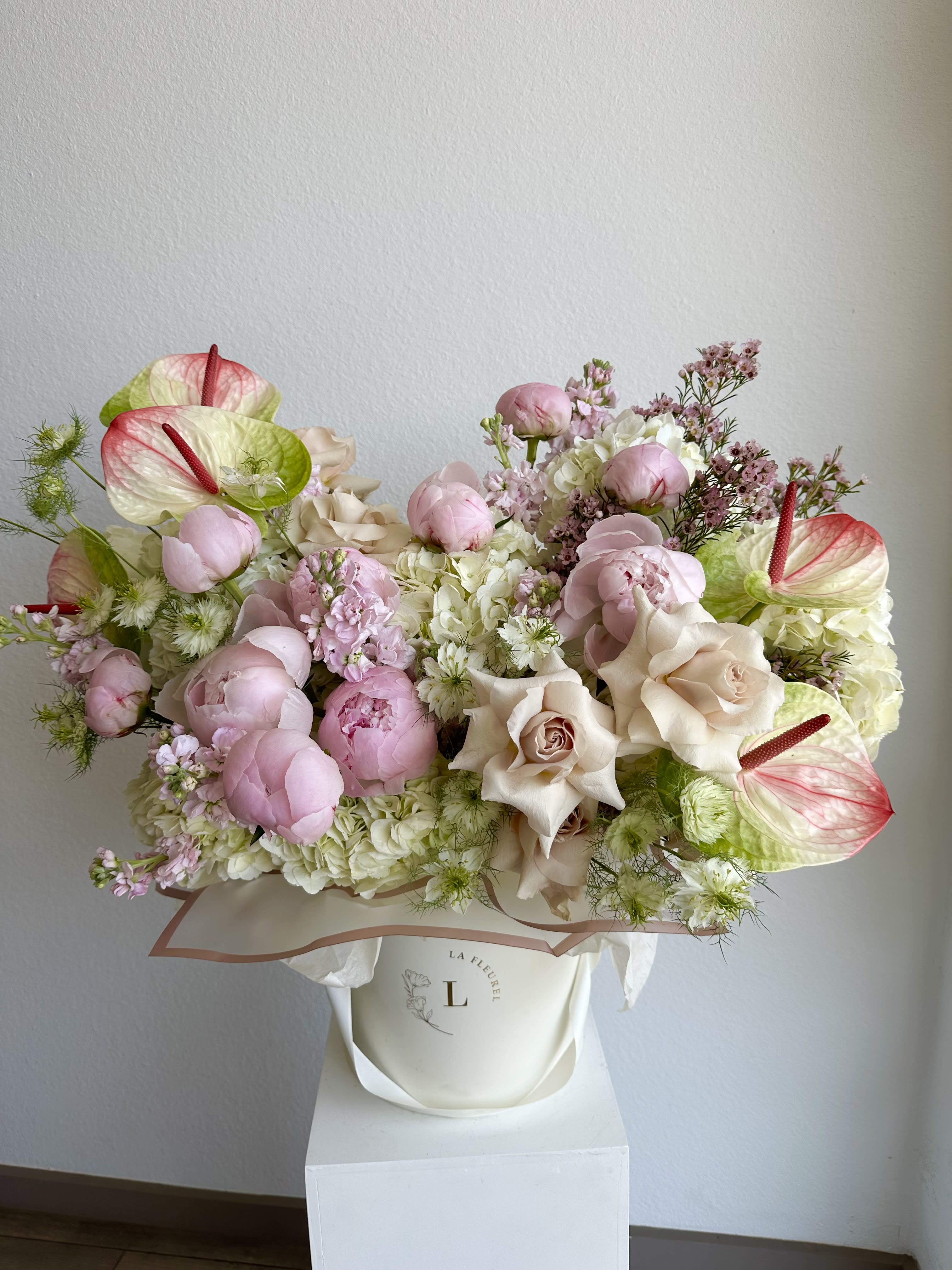 Amelia's Garden - This romantic arrangement includes roses, hydrangeas, peonies, anthurium and greens.  Perfect for any occasion. You can choose any color of the box.  Arrangement includes:  Medium Box Custom greeting card