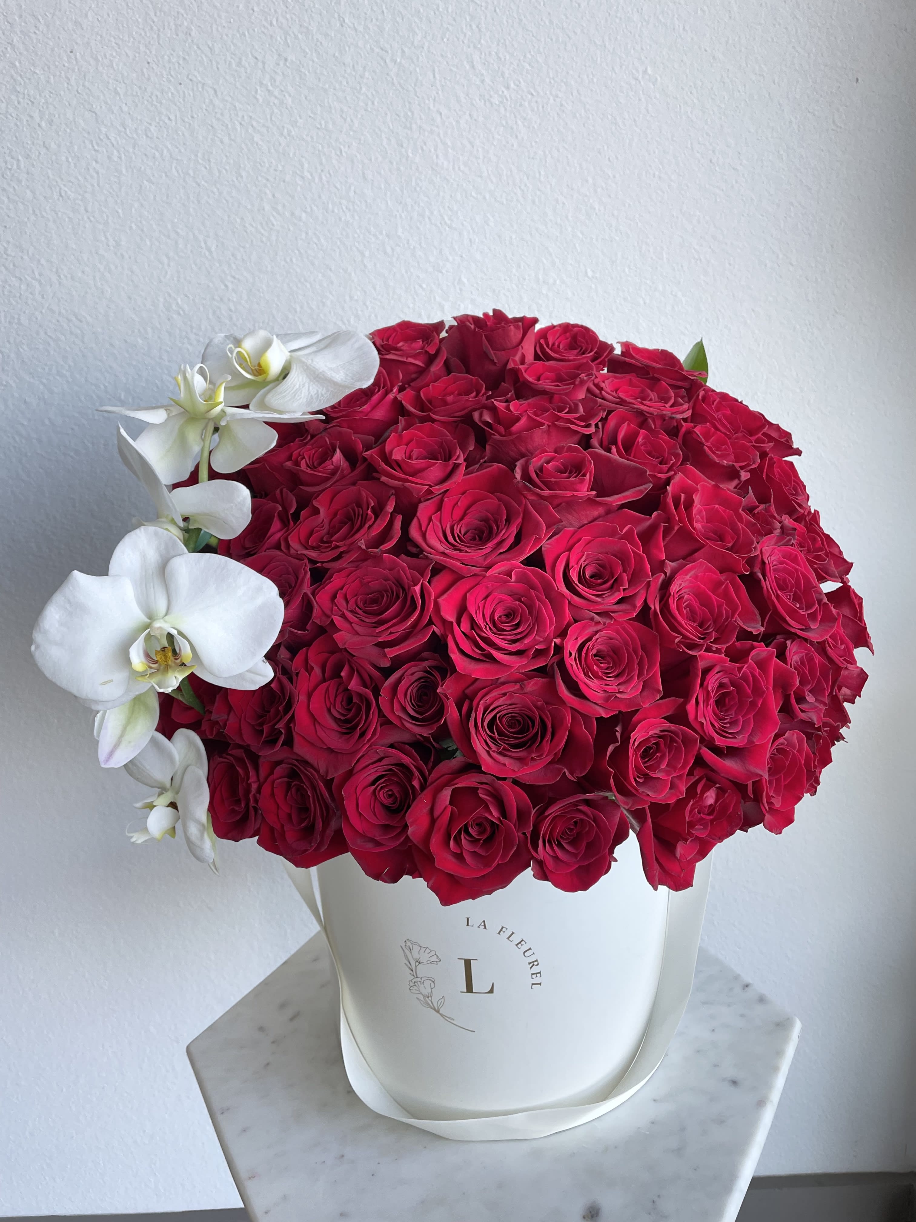 Classic Red arrangement in Ivory box - This beautiful arrangement filled with the red roses to deliver your special message to your special someone.  Perfect for any occasion. You can choose any color of the box.  Arrangement includes: red roses  Medium box measured at 9.75" Dia. x 9.25" H Custom greeting card