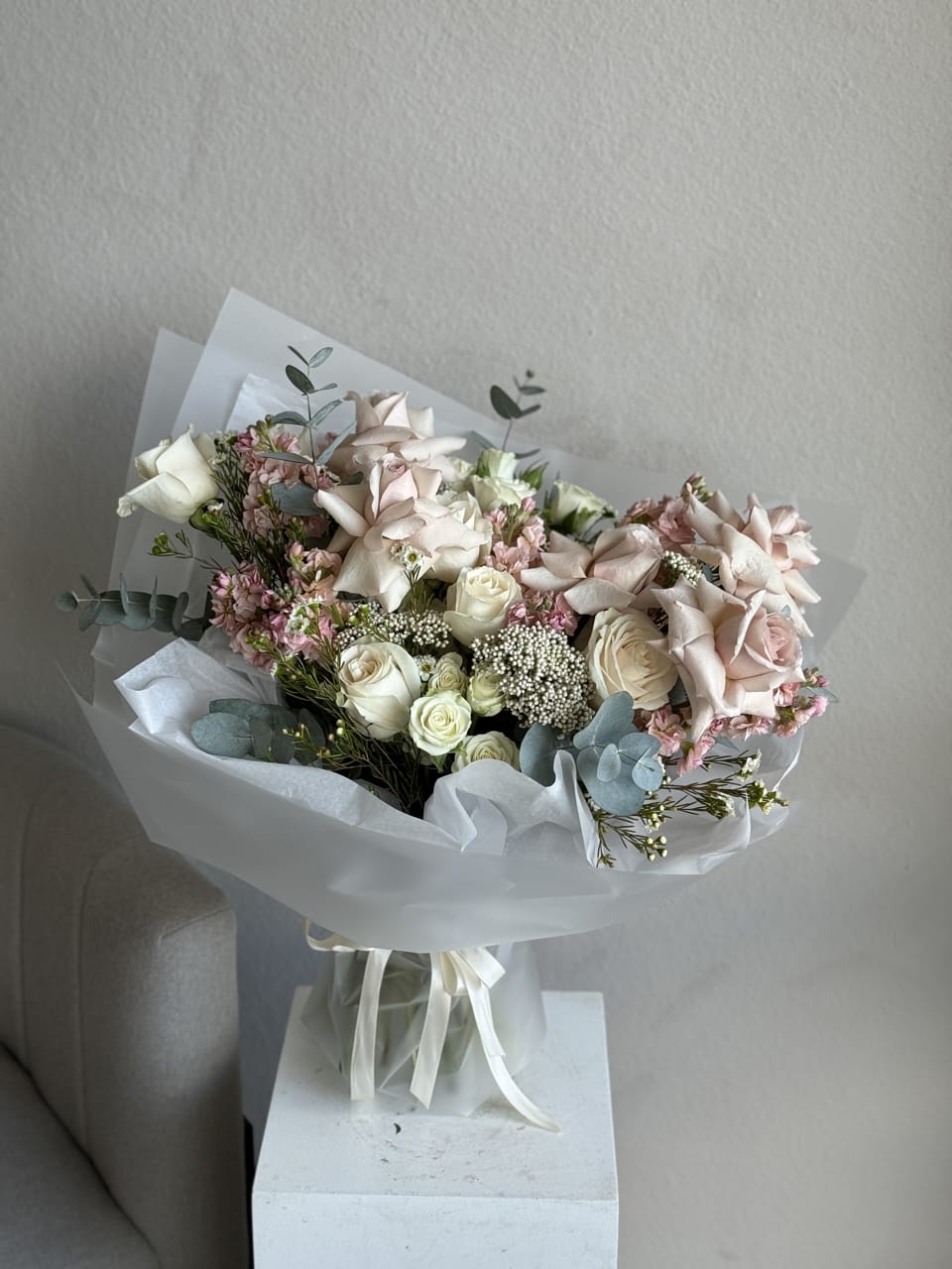 Charm Hand held Bouquet - The Charm Bouquet is a delightful handheld arrangement featuring an array of blush-colored flowers. This elegant bouquet exudes romance and grace, making it a perfect choice for any special occasion.