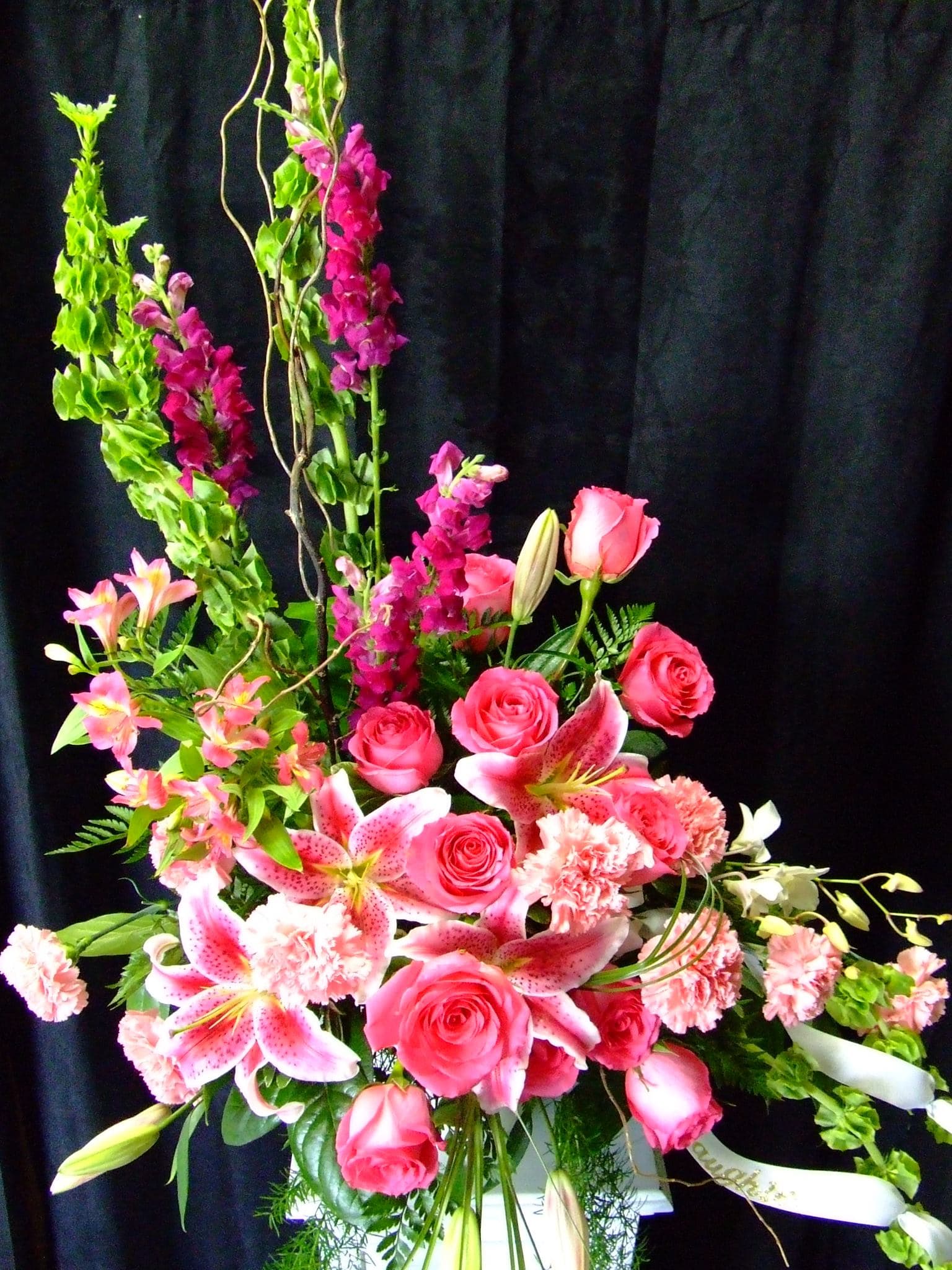 Pink Remembrance - pink roses, lilies, Snap Dragons, Bells of Ireland, Alstromeria,  carnations