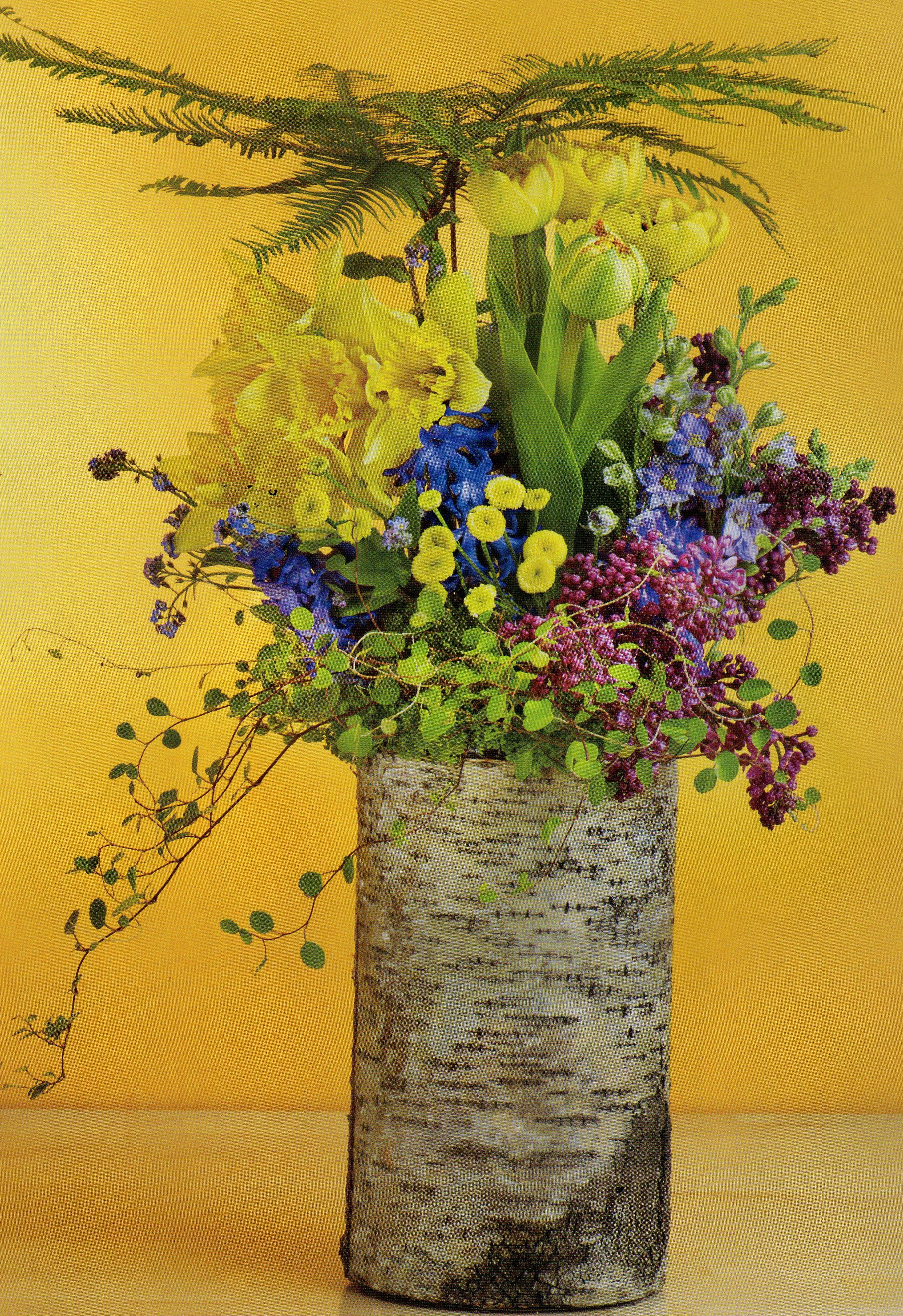 Nature Walk - This enchanting bouquet comes in a natural birch bark vase filled with a breath of spring air- tulips, lilac, and larkspur and more join moss and free spirited foliage.