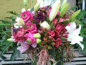 Spring Forward Spring Forward - Ranuculus, oriental lilies, hypericum berries, alstromeria, cymbidium orchids, mums in clear glass vase wrapped with espidistra leaf.
