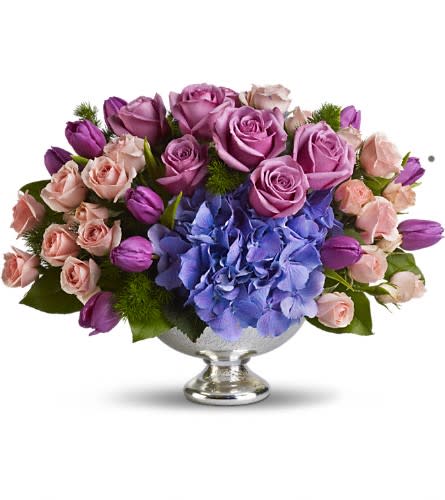 Teleflora's Purple Elegance Centerpiece - A masterpiece in purple. This lush lavender array mixes beautiful blue hydrangea with happy purple tulips and luxurious lavender and pink roses. Presented in an elegant Mercury Glass Bowl it's an exquisite choice for any important event from weddings to showers. Purple tulips blue hydrangea lavender and pink roses are mixed with delicate ming fern and rich green salal in a magnificent Mercury Glass Bowl.Approximately 17&quot; W x 12 1/2&quot; H Orientation: All-Around As Shown : T197-1A