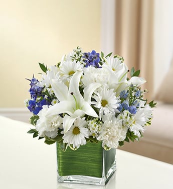 Blue &amp; White Healing Tears - Send your deepest care and concern during times of sorrow with our precious blue and white sympathy arrangement. The freshest roses, delphinium, lilies, daisy poms and carnations are hand-designed in a stunning cube vase as a gesture of comfort and peace.