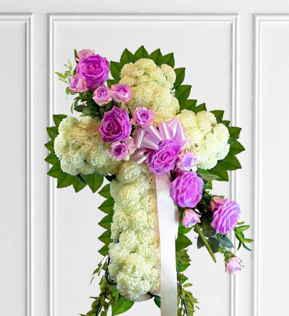 Faith Sympathy Cross Faith Sympathy Cross - White and Lavender Sympathy Cross. White flowers surrounded by foliage and a lovely array of lavender roses cascading. Lavender represents refinement, grace, and elegance.