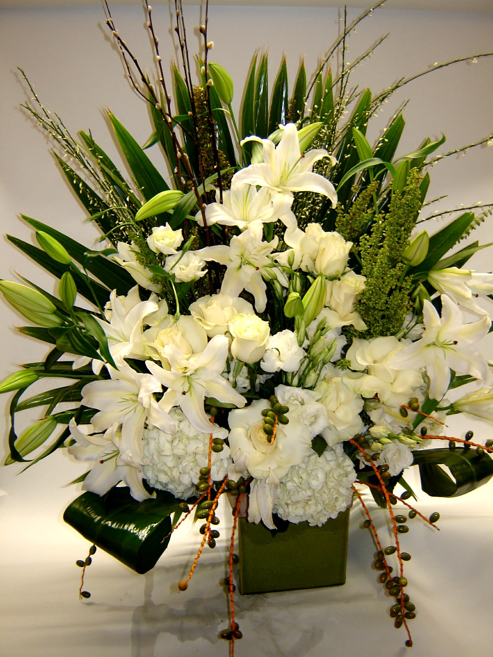 Dazzling White Dazzling White - A sassy, yet elegant white arrangement with pussy willow, Casablanca lilies, roses, hydrangea, lisianthus and berries.