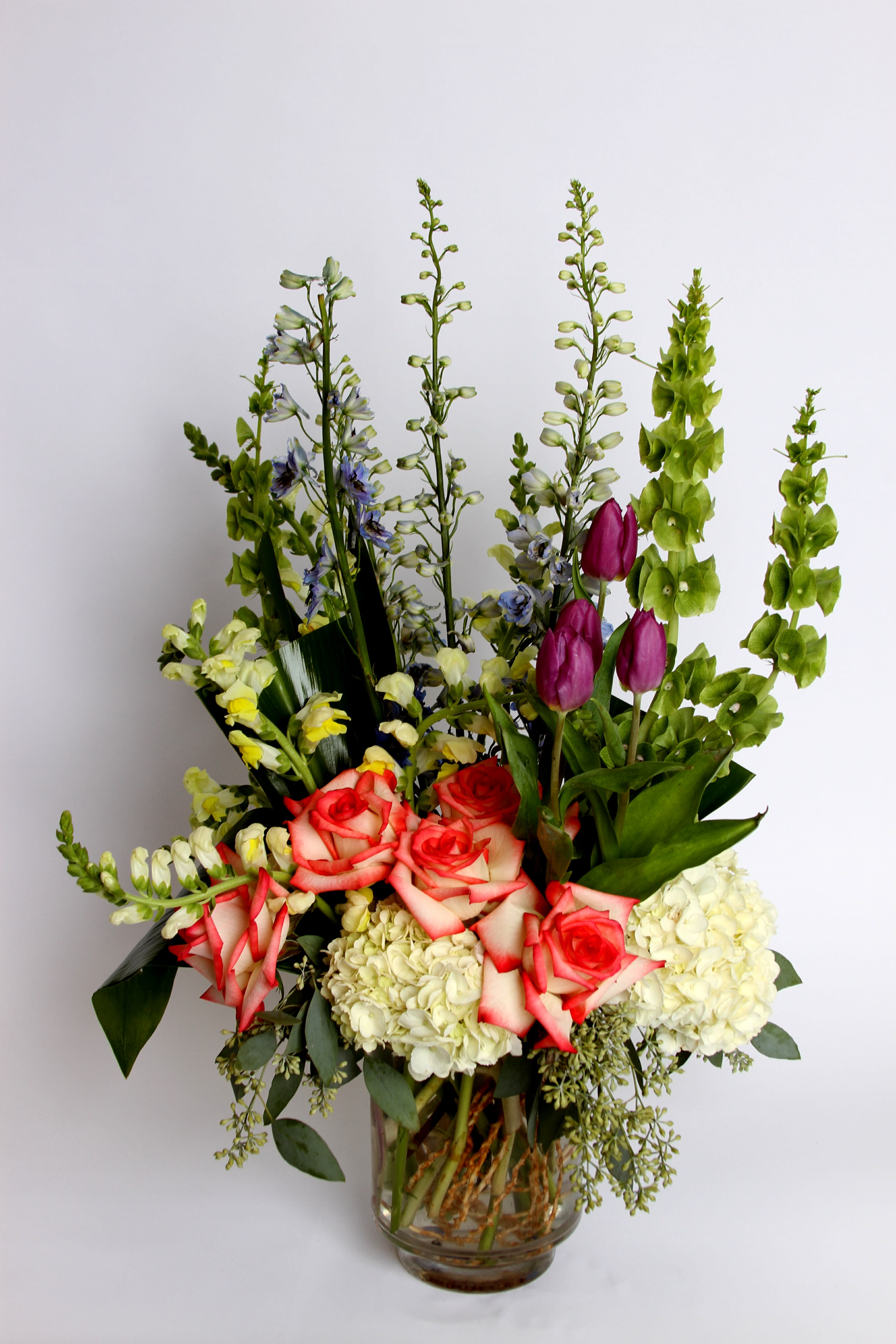 Flowing Garden Flowing Garden - Bells of Ireland, delphinium, roses, hydrangea,tulips and snapdragons in a quaint arrangement, reminiscent of flowers picked fresh from a garden