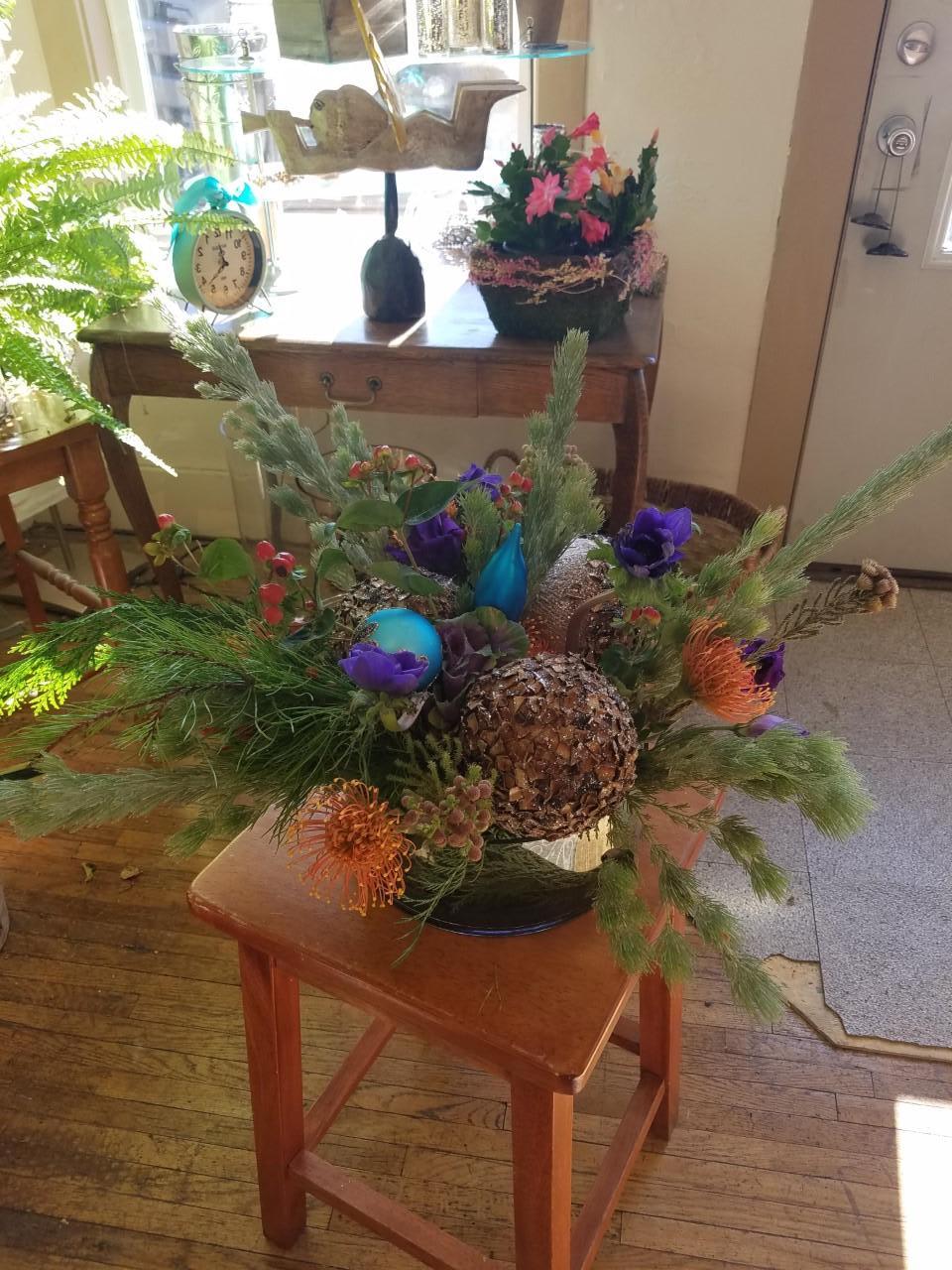 christmas celebration bouquet   - here is a beautiful vase of winter greens and flowers with touch of holiday ornaments.  colors based on availability, but we will pay attention to requests.