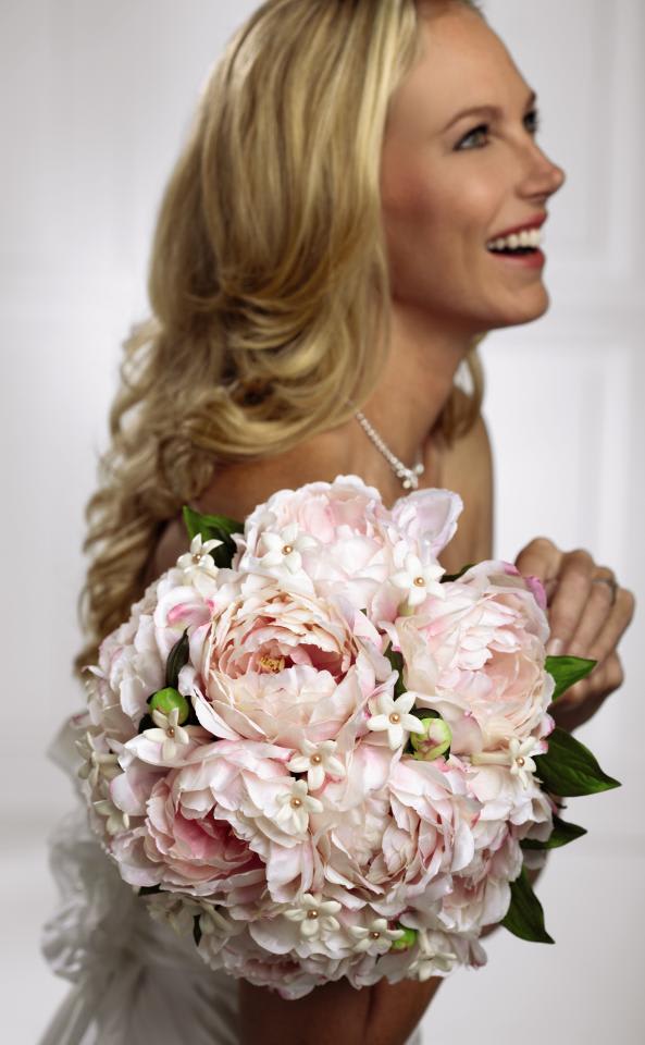 Peony Bridal Bouquet -  Bouquet is a blushing display for sweetness  that will make any bride smile. Gorgeous pink peonies show off their  amazing texture accented with white stephanotis blooms and tied together  at the stems with a brown shiny taffeta ribbon to create a bouquet you  will never forget. Approx. 11-inches in diameter.