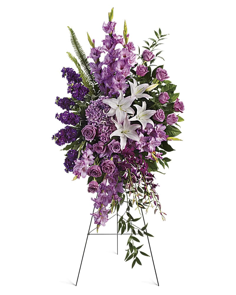 Sacred Garden Spray - Blessed, peaceful rest is expressed in this cascading purple spray accented with white lilies. Such graceful grandeur would honor a memorial service.   •Peaceful blooms such as lavender roses, gladioli and hydrangea, with purple orchids and white oriental lilies. •Orientation: One-Sided 
