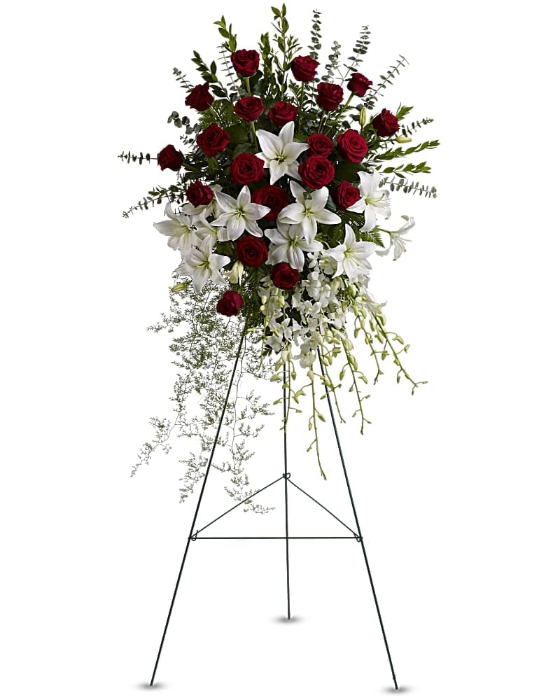 Red Rose and Liliy Spray - Make a statement of enduring love and tribute with this dramatic lily and rose funeral spray, presented on an easel for ease of placement. Red roses, white lilies and cascading white orchids are elegant funeral flowers fit to honor someone truly special.   •Red roses, white asiatic lilies and delicate dendrobium orchids are accented with myrtle, sprengeri fern, leatherleaf fern and spiral eucalyptus on a traditional wire funeral easel. •Orientation: One-Sided 