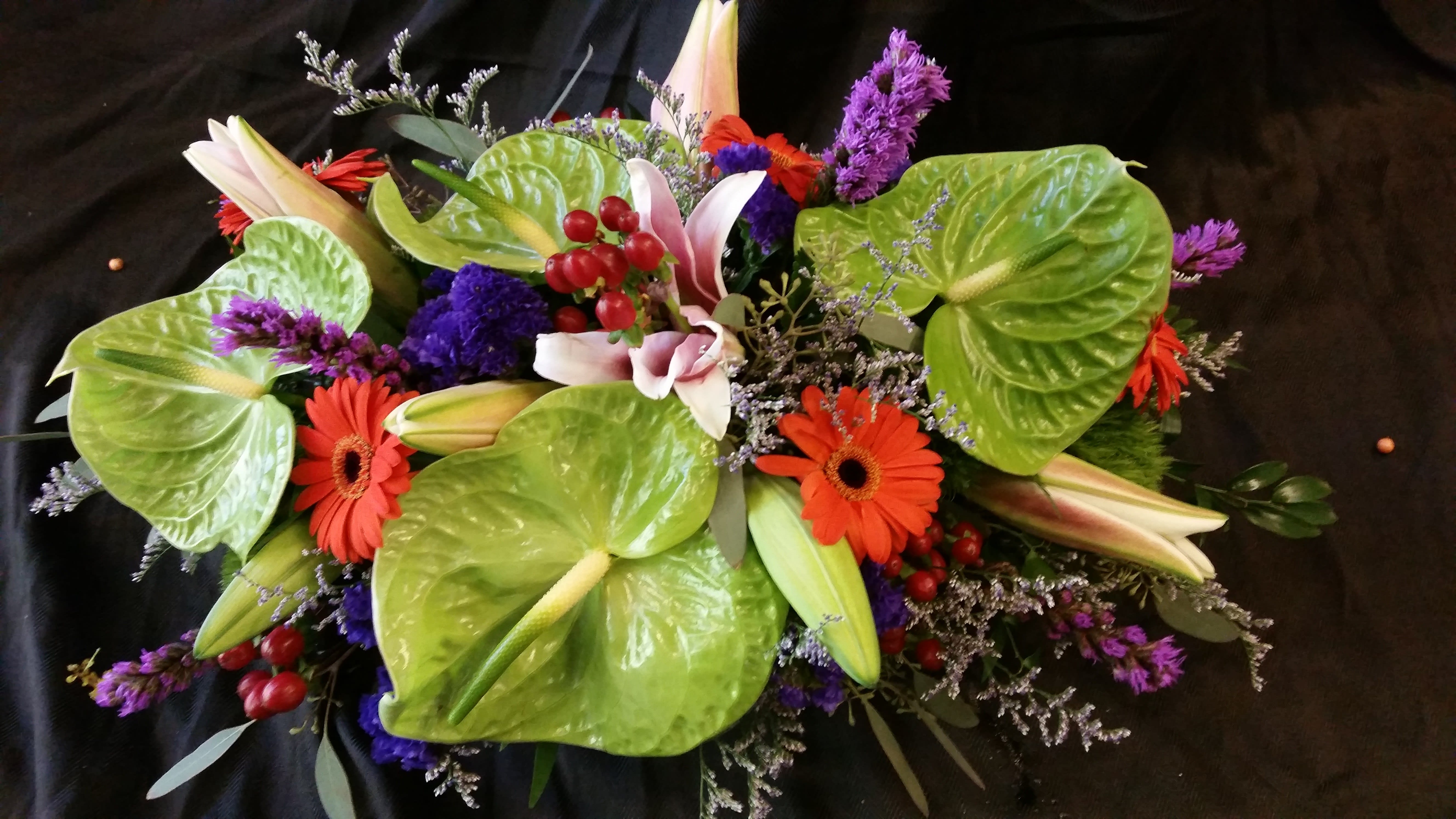 paradice - green anturiums, orange gerbera, and lilies.