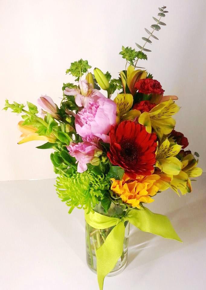 Birthday Joy - Wish someone a Happy Birthday with this colorful splash of flowers.Alstromeria, carnations, lillies, gerbera daisies and greenery are nestled together to convey a message of joy! An apple green ribbon tie accents the vase.