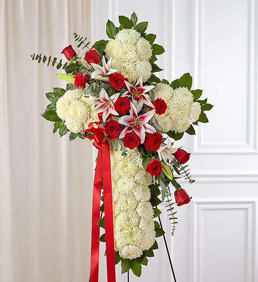 Red Rose and Lily Standing Cross - Our magnificent standing cross is created from fresh white mums designed with a vibrant cascade of rich ruby red roses and majestic Stargazer lilies. A heartfelt expression of sympathy and faith, this tribute will serve as a memorial to a family member who inspired faith and love.