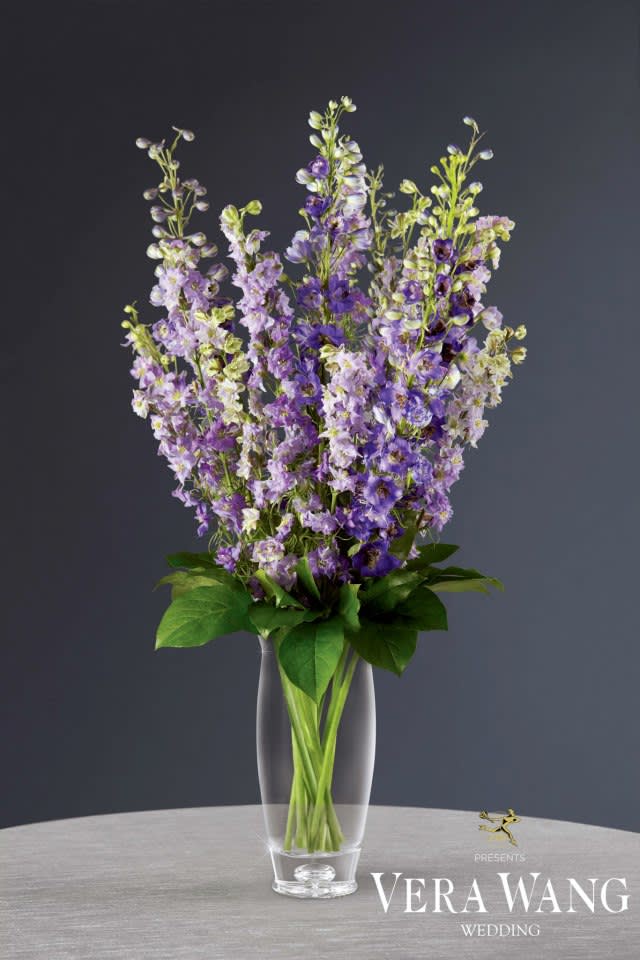 VWM16 - The Light of Love™ VWM16 - The Light of Love™ - The Light of Love™ Centerpiece by Vera Wang has a sophisticated style that will add to the magnificent beauty of your wedding day celebration. Lavender larkspur and purple delphinium are simply lovely offset by lush greens and arranged to perfection in a clear gass teardrop vase for the optimal effect of modern day elegance.