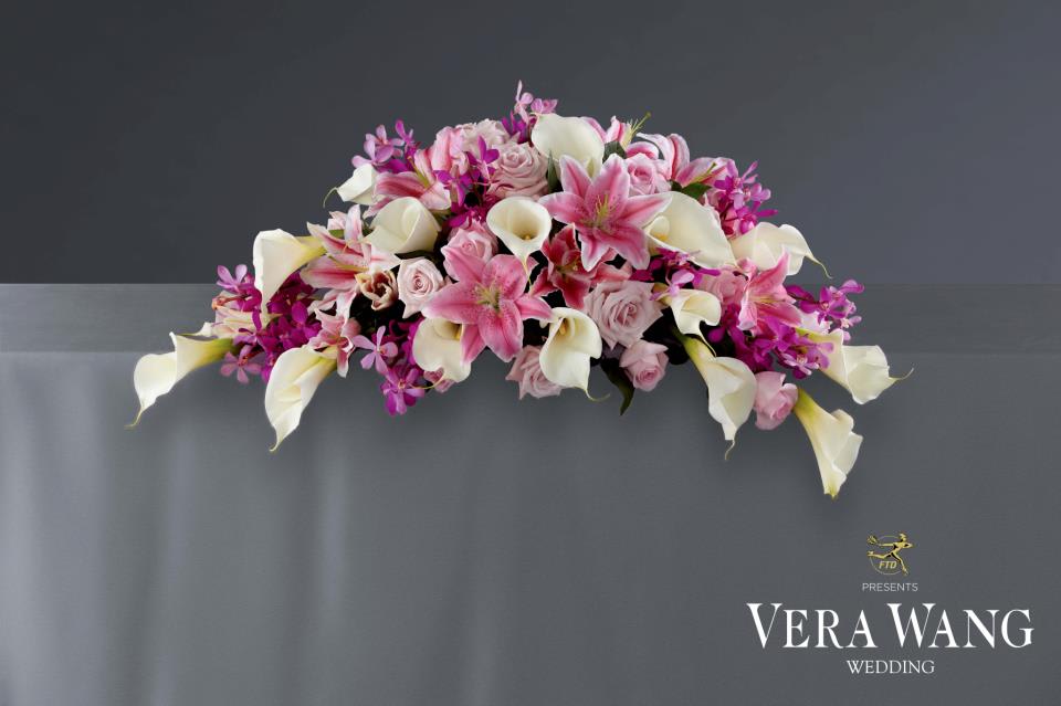 VWR12- The Blessed Day™ Arrangement by Vera Wang VWR12- The Blessed Day™ Arrangement by Vera Wang - The Blessed Day™ Arrangement by Vera Wang will be the perfect touch for the altar or the head table with its bright and beautiful colors and textures. White open cut calla lilies pop against the vibrant colors of fuchsia mokara orchids, light pink roses, pink roses, pink Oriental Lilies, bi-colored pink Oriental Lilies, and fresh greens to create a fantastic arrangement that will add to the magic of your special day.