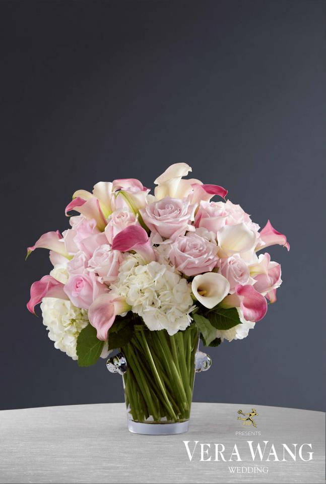 VWR15- The Love's Calling™ Centerpiece by Vera Wang VWR15- The Love's Calling™ Centerpiece by Vera Wang - The Love's Calling™ Centerpiece by Vera Wang is a sumptuous display of floral elegance. Pink mini calla lilies, light pink and pink roses, blush mini calla lilies, and white hydrangea are beatifully arranged in an exquisite clear glass ice bucket to create the ultimate centerpiece for your reception.