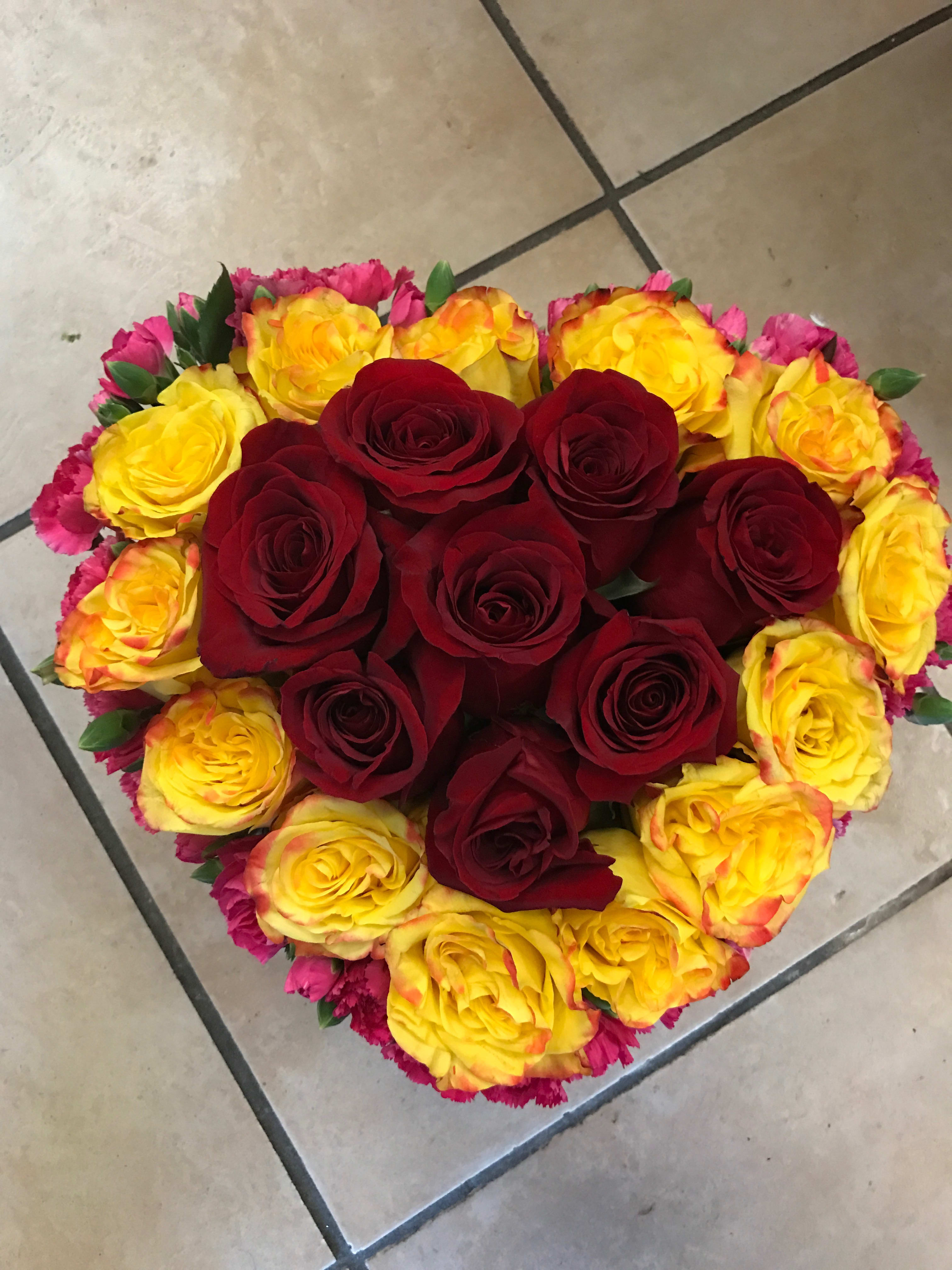 Small Heart Shaped Arangment  - This beautiful heart shaped arrangement really shows your love for someone with bursting colors. Roses and carnations mix beautifully to showcase this amazing arrangement 