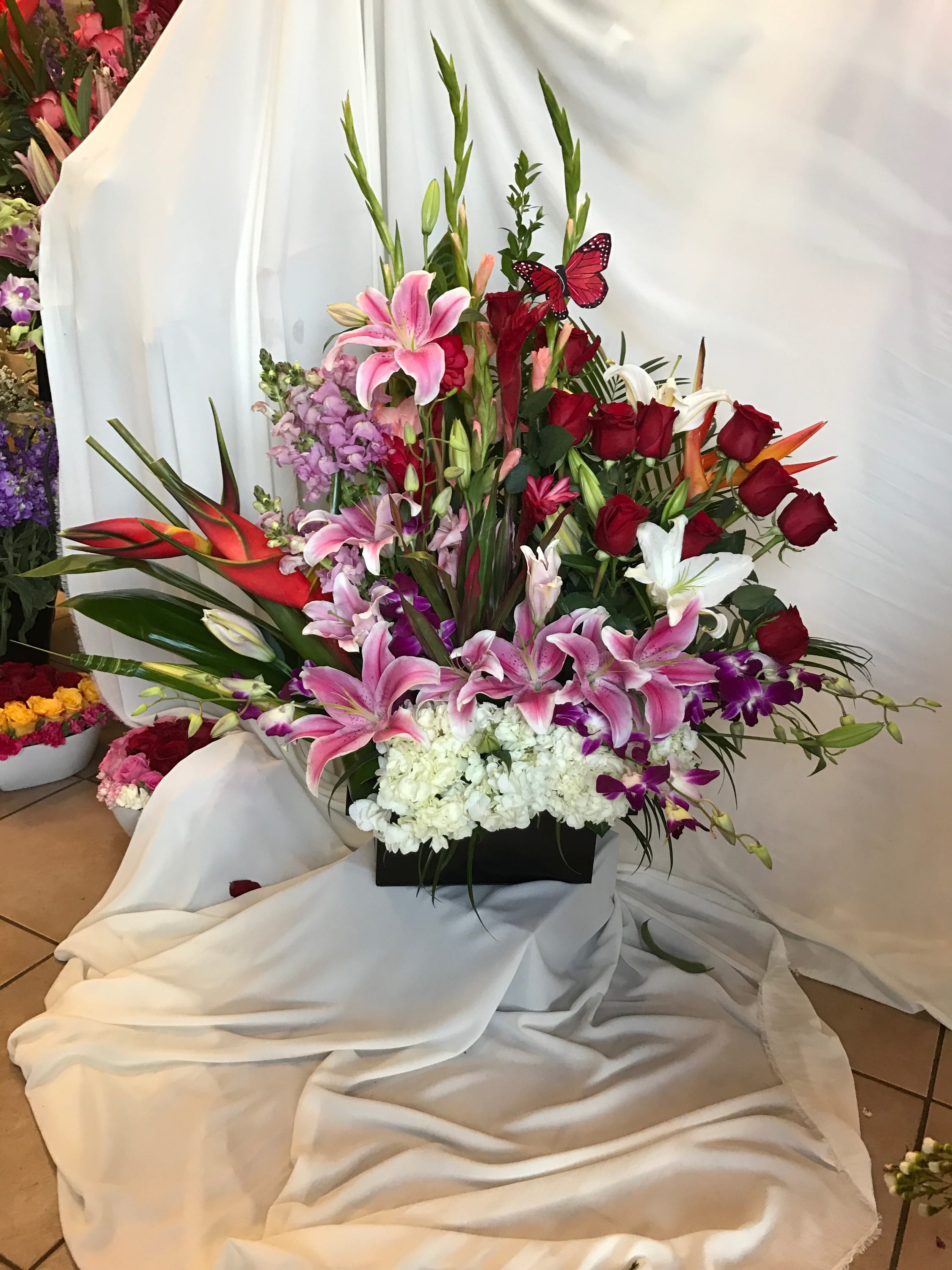 Tall tropical colorful arrangement  - This tall arrangement is filled with tropical flowers in a rectangle pot. 