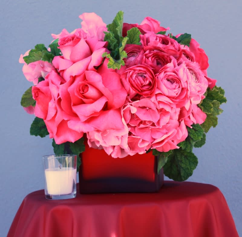 Pretty In Pink - Pink Roses, Pink Hydrangea, Ranuncula's, Geranium, Sweet Peas. In a red frosted square vase.